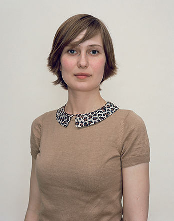 A Rineke Dijkstra portrait of a woman in a beige blouse with short hair.