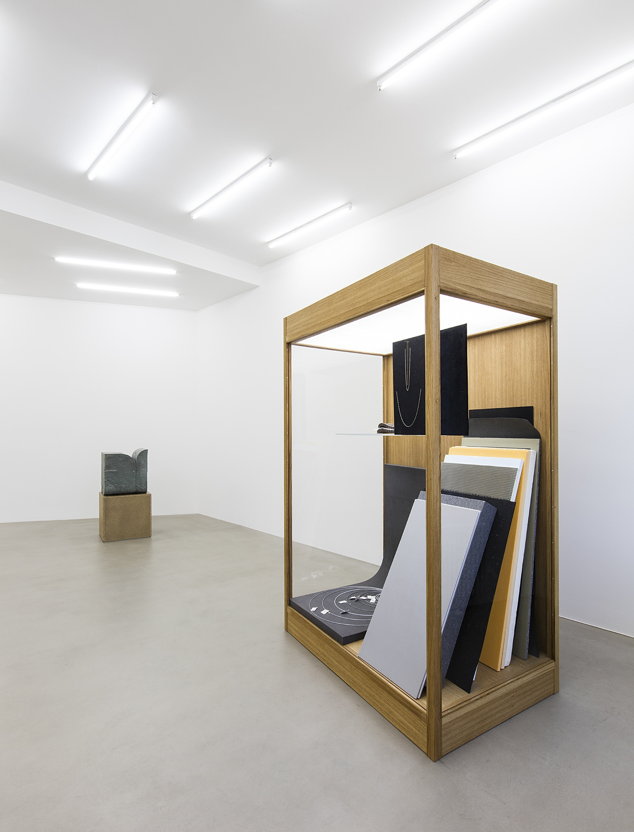 I collate, I convey, I comply (01), 2015 (back) Green Anröchter stone, chipboard plinth, assorted objects The sculpture’s combination of...