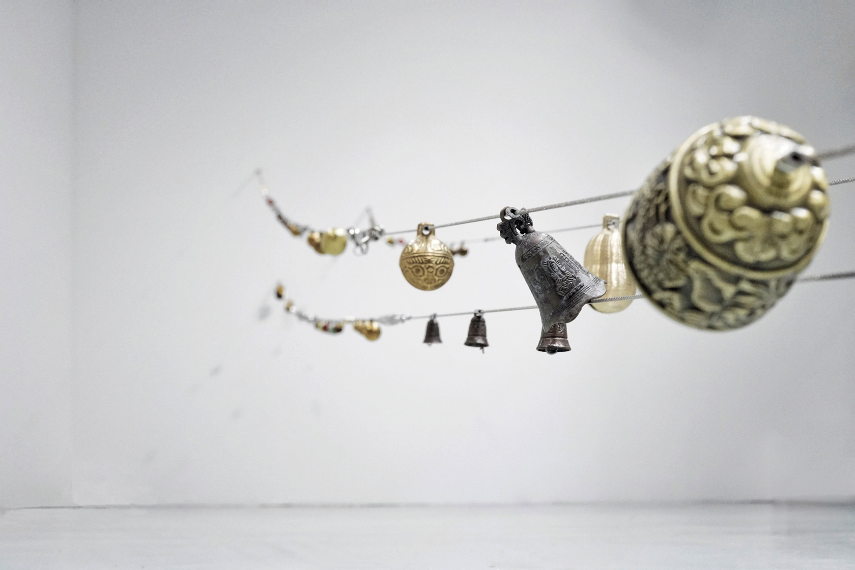 Dragon's Tail, 2016 (detail) Chinese bells and carved seeds, steel cable, turnbuckles, hardware. 3 parts: 638 cm x 620 cm...