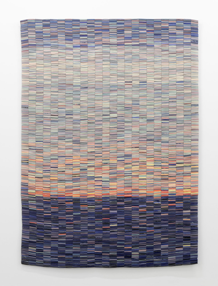 An artwork by Nadia Myre of ceramic tubular beads strung together into a cohesive rectangular with dark blue beads at the bottom and lighter orange, yellow and blue beads above.