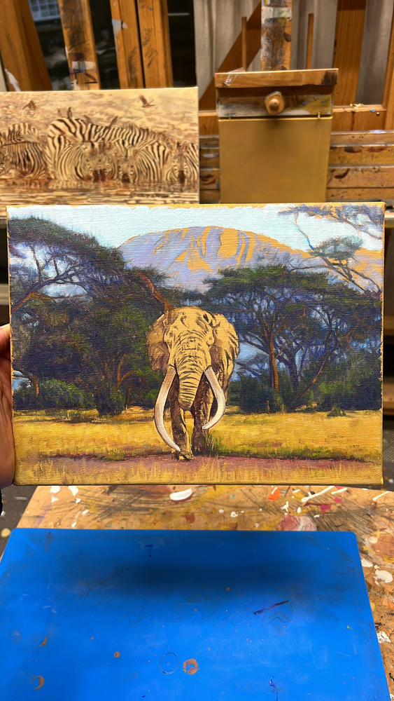 John Banovich
In the Footsteps of Giants, 2026
oil on Belgian linen
9h x 12w in
22.86h x 30.48w x 1.91d cm
$ 7,300.00
&amp;nbsp;

As I watched this bull elephant walk toward me, I was reminded that I was quite literally standing in the footsteps of giants. His path had been worn into the land long before my own, shaped by generations that know this place far better than we ever will. There was a calm certainty in his movement, a quiet strength that needed no display.

The acacia trees and Mount Kilimanjaro behind him felt timeless, as if they were holding the memory of every elephant that has passed through this valley. Painting this moment slowed me down. It reminded me that to follow in the footsteps of giants is to move with humility, respect, and care for a world that does not belong to us, but one we are responsible for protecting.