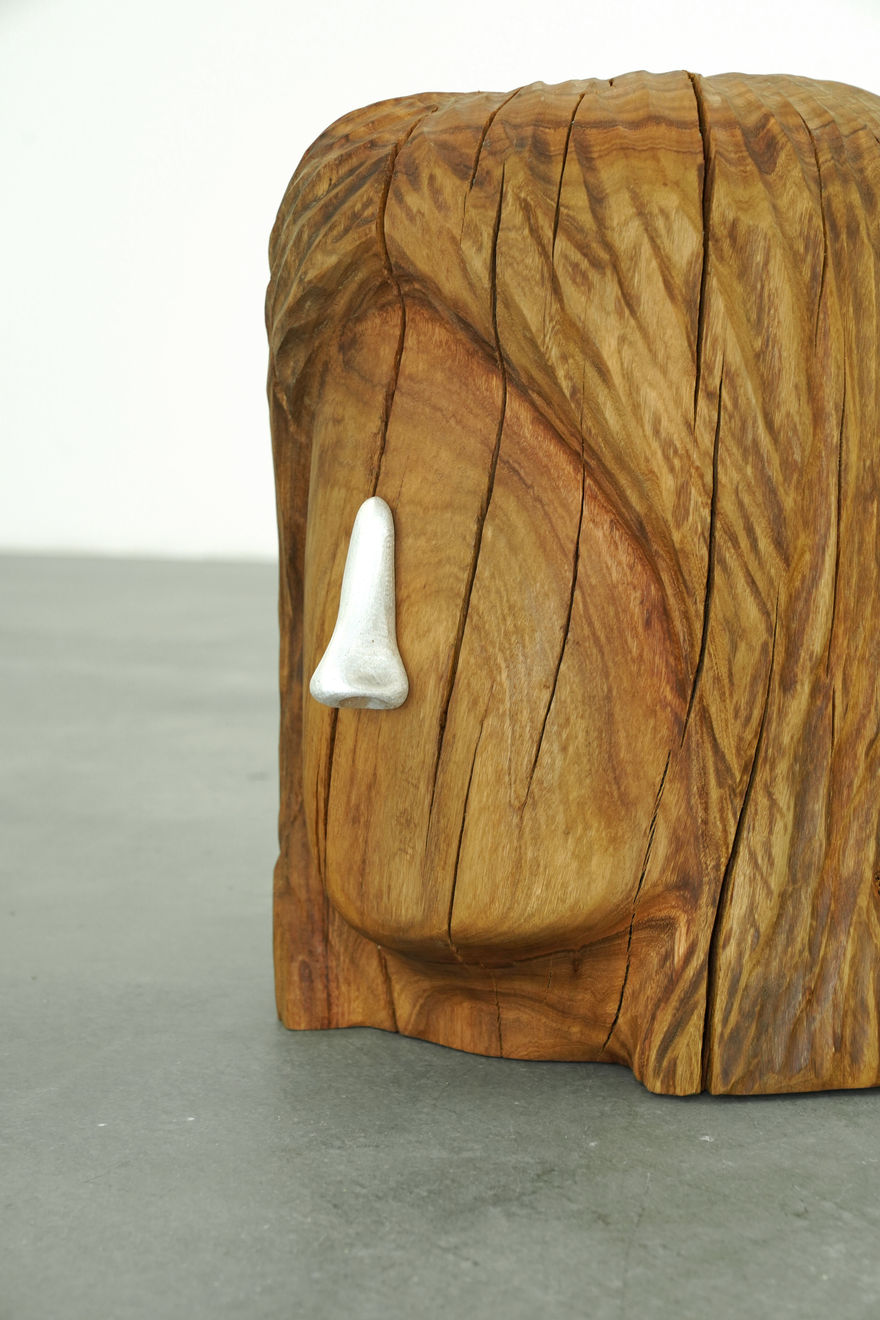 wooden stool shaped into a head with metal nose