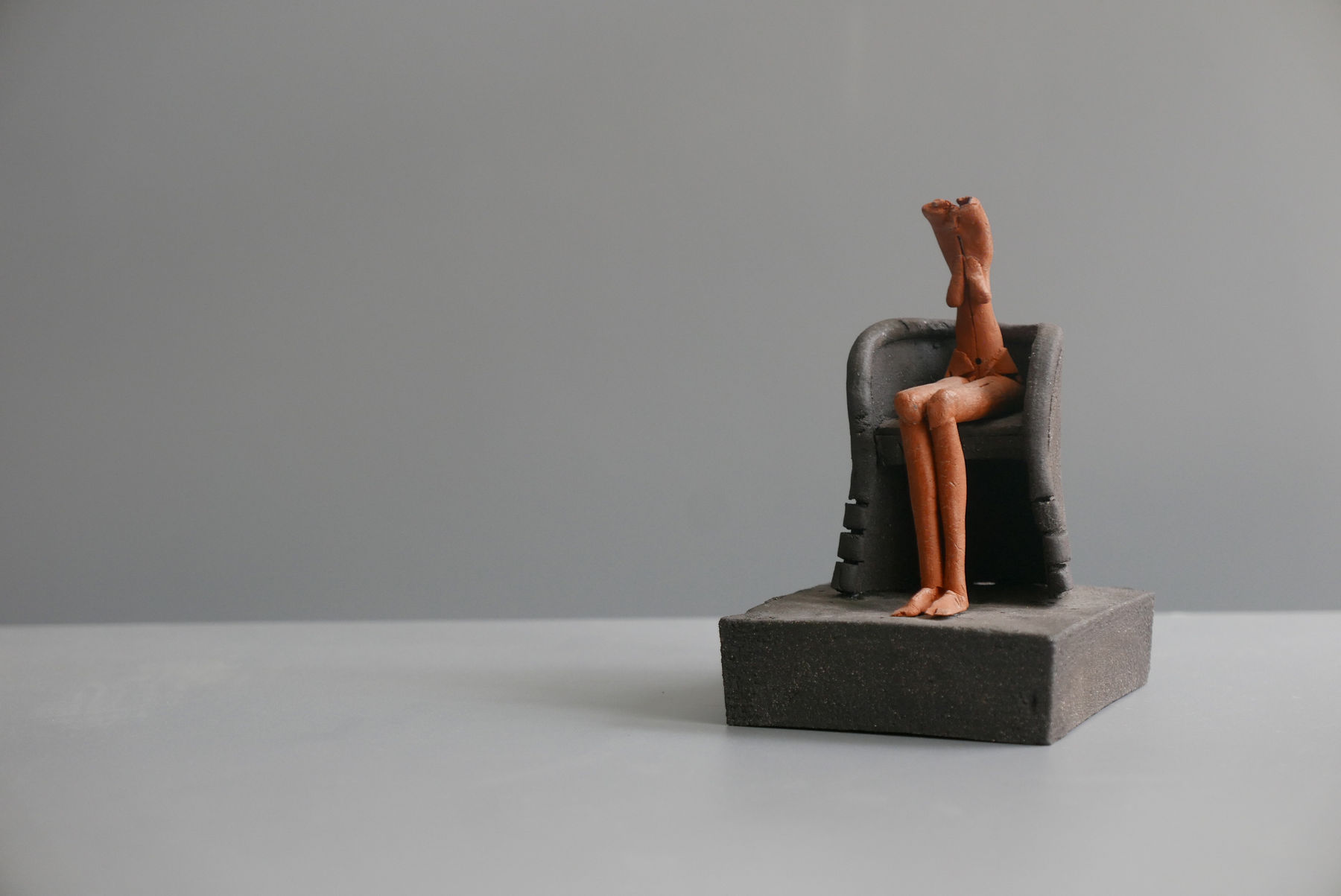 Mo Jupp, Terracotta Figure Seated in a Black Armchair
