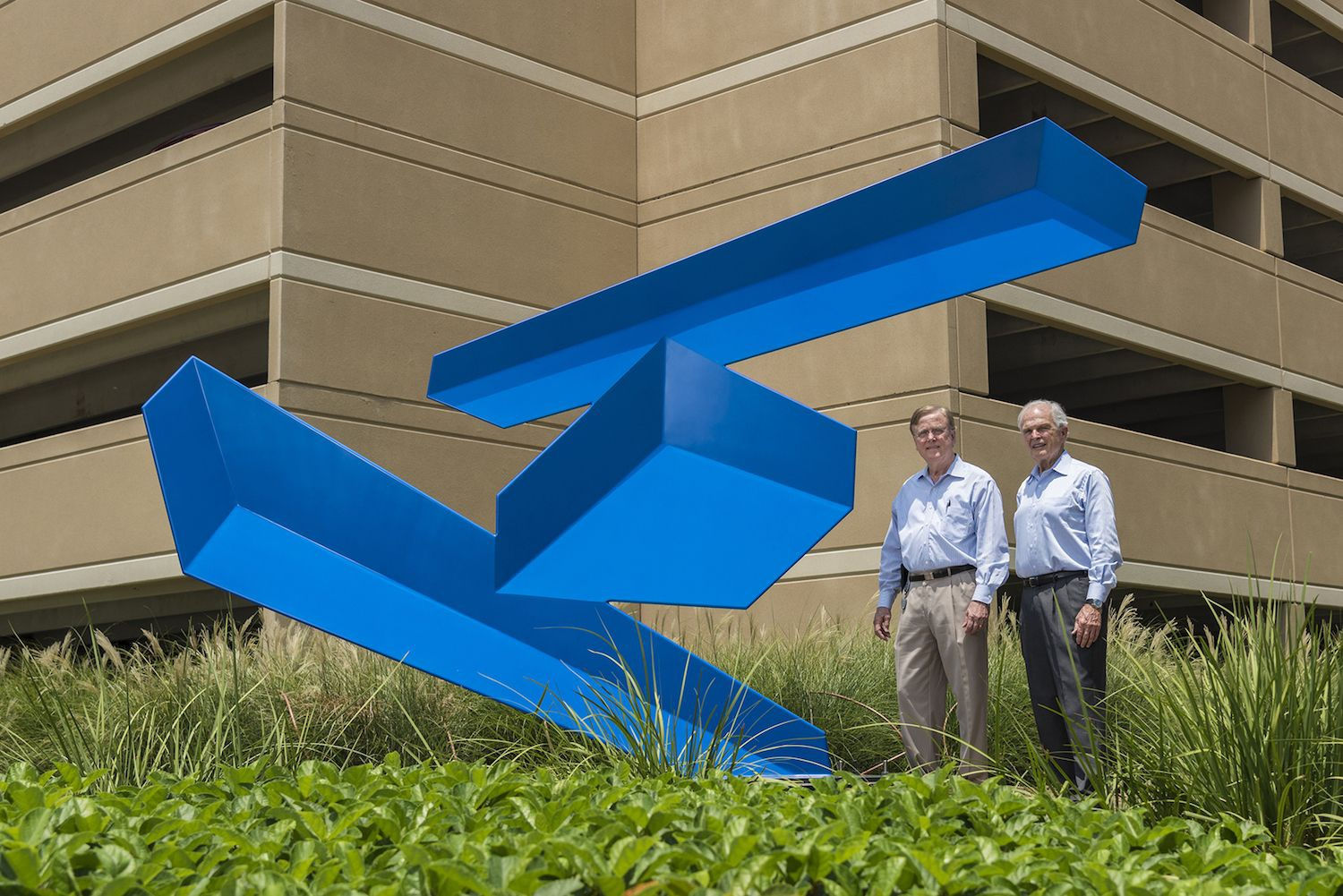 Robert Heineman (left), vice president of planning, and Peter Doyle (right), executive vice president of strategic development, both with The Howard Hughes Corp., have orchestrated selections of the various sculpture pieces for Hughes Landing with the assistance of Kinzelman Art Consulting. The latest installation is Acrob&aacute;tica, a sculpture by Rafael Barrios in Hughes Landing.