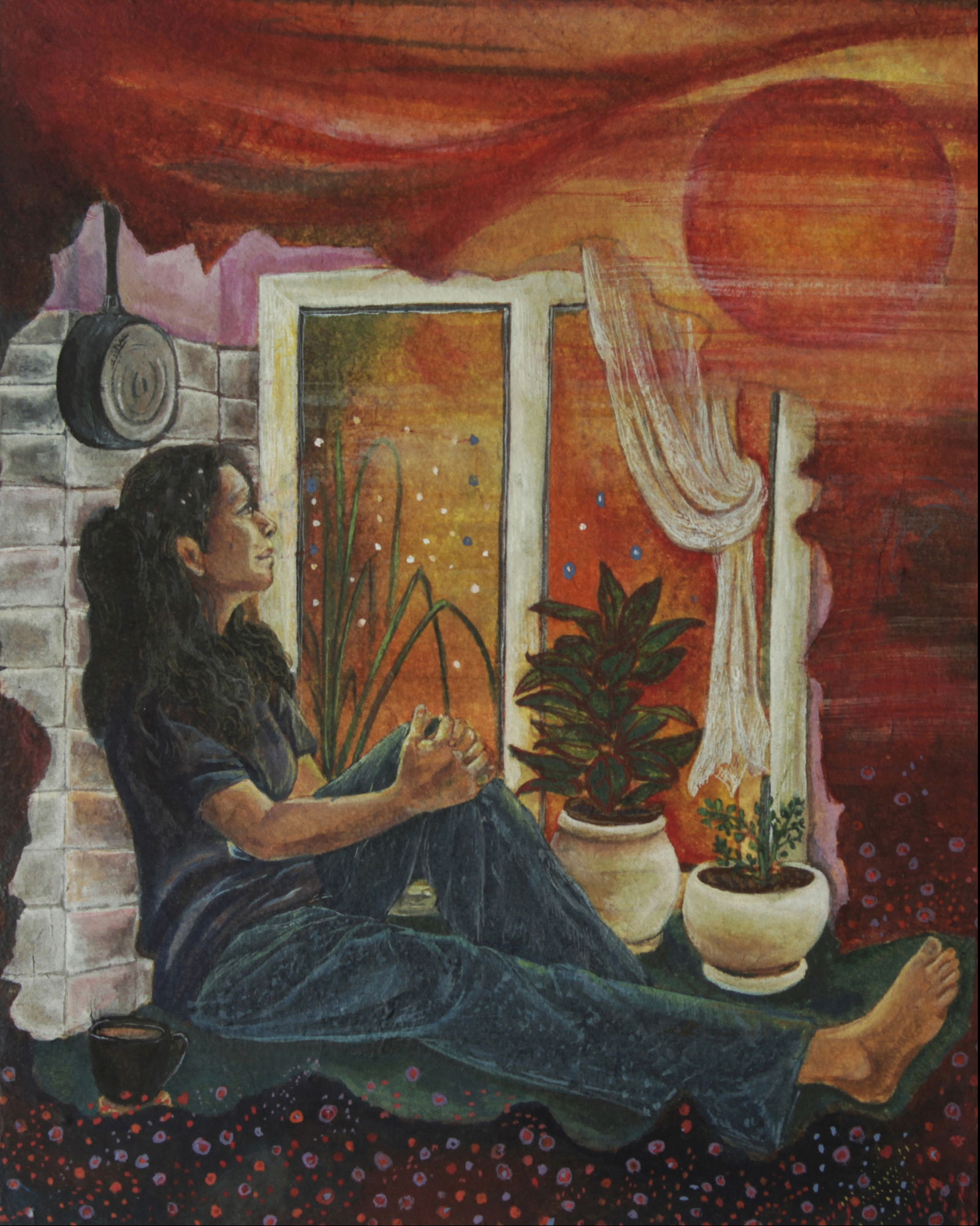 A woman seated inside her home looking at a sunset through her curtained balcony