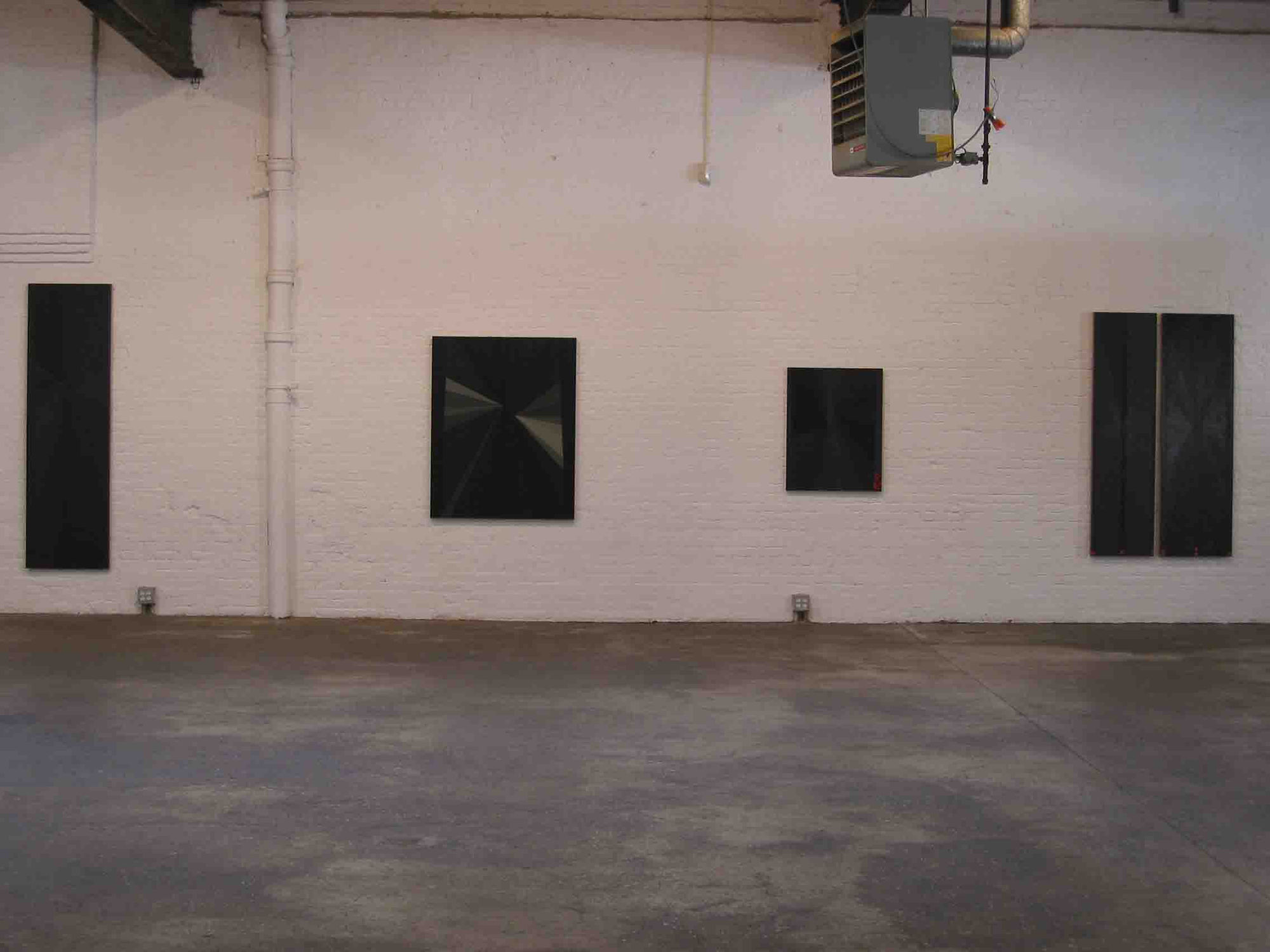Installation view of Mark Grotjahn's first show at Anton Kern Gallery, featuring a series of bold geometric paintings. The darker paintings featured.