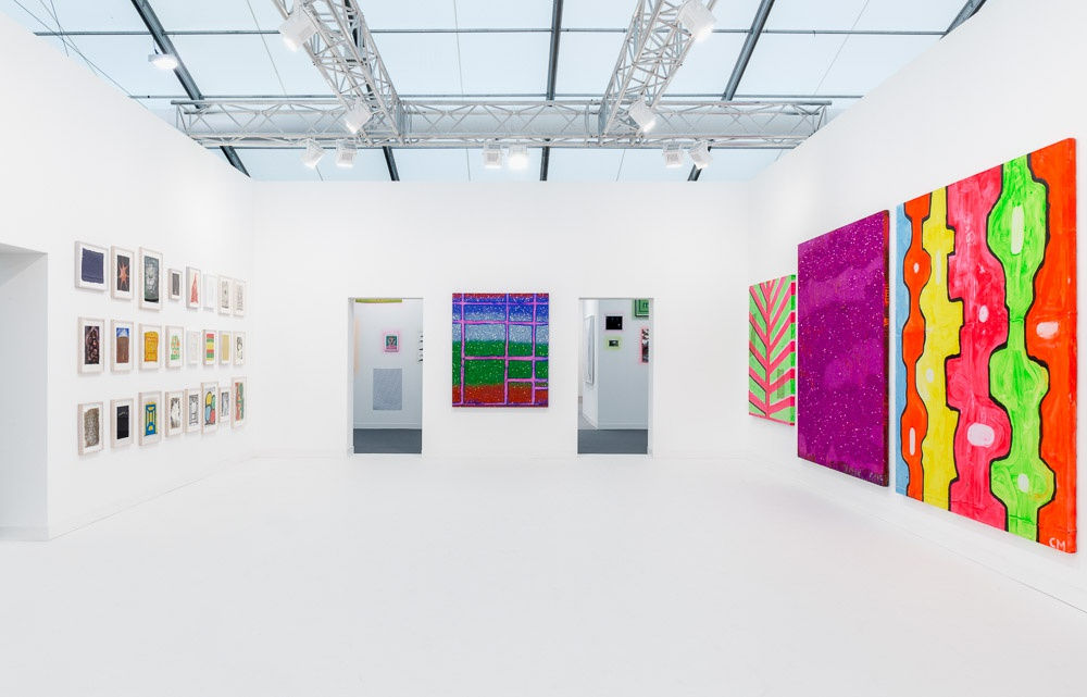 Installation view of Chris Martin's solo exhibition at Frieze London 2015. Straight-on view of entrance into booth.