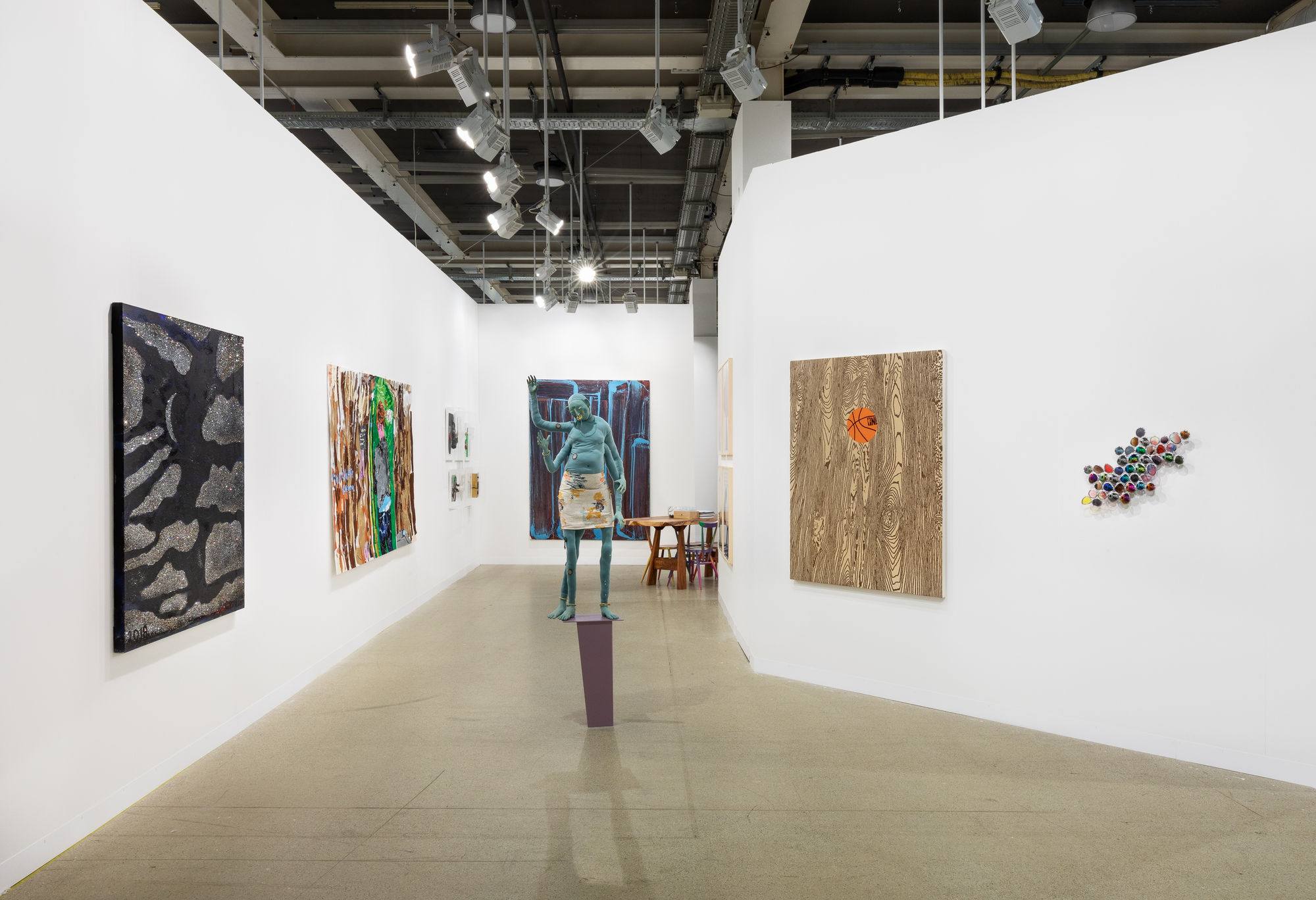 Installation view of Art Basel featuring the majority of works in the both, including sculptures, paintings, and more.