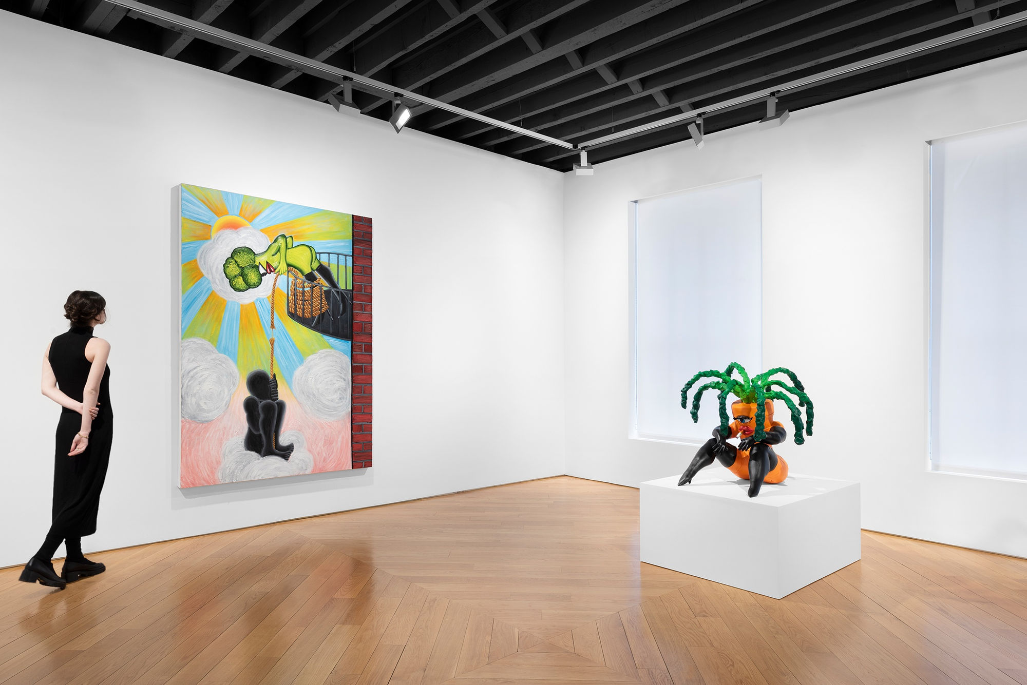 Installation view in corner of gallery with windows. Includes carrot-shaped sculpture on white plinth, large painting and visitor for human scale. Works pictured: "Struggling," 2022 and "Sitting Carrot."