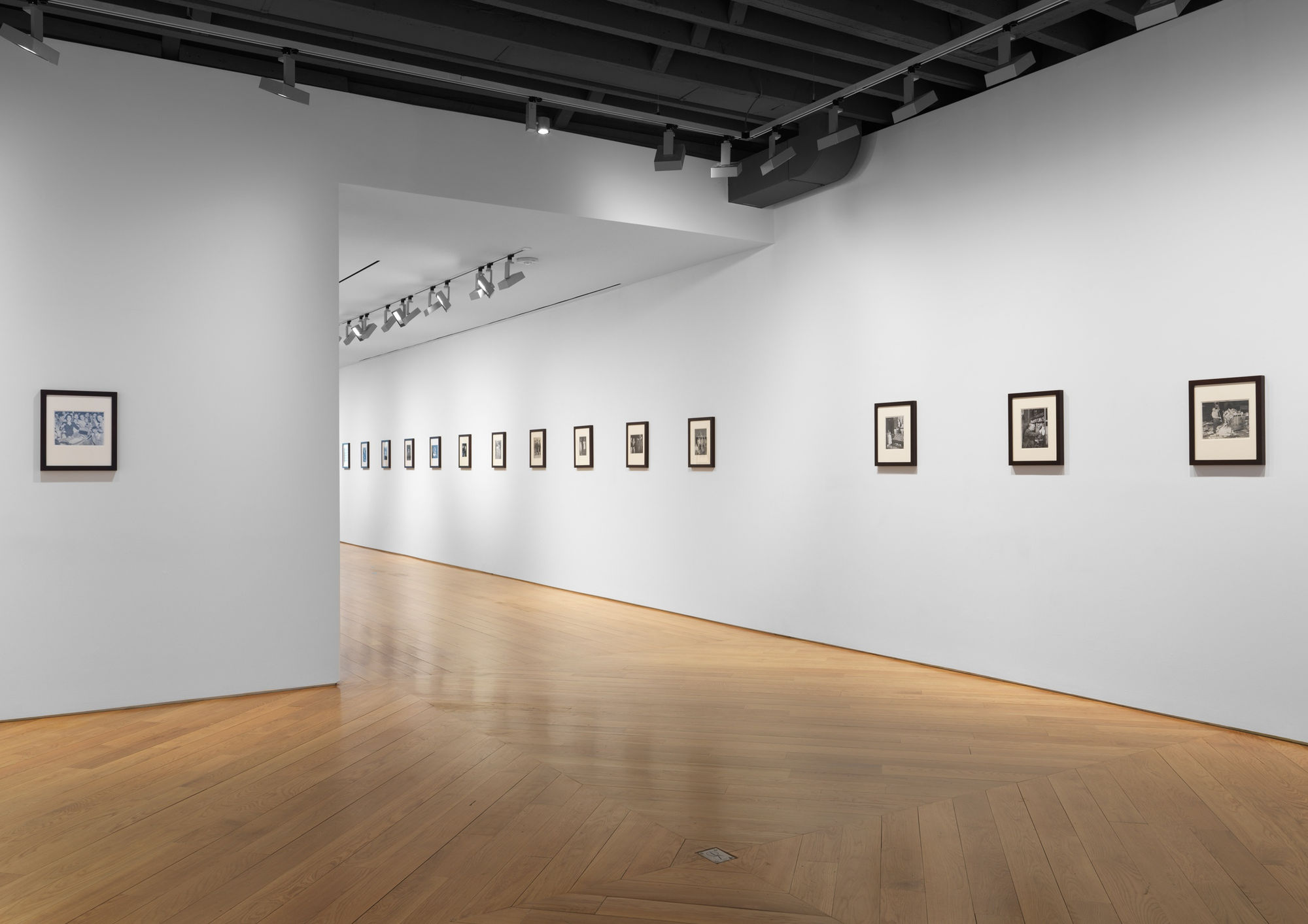 Installation view of vintage Weegee photos. Many small works shown.