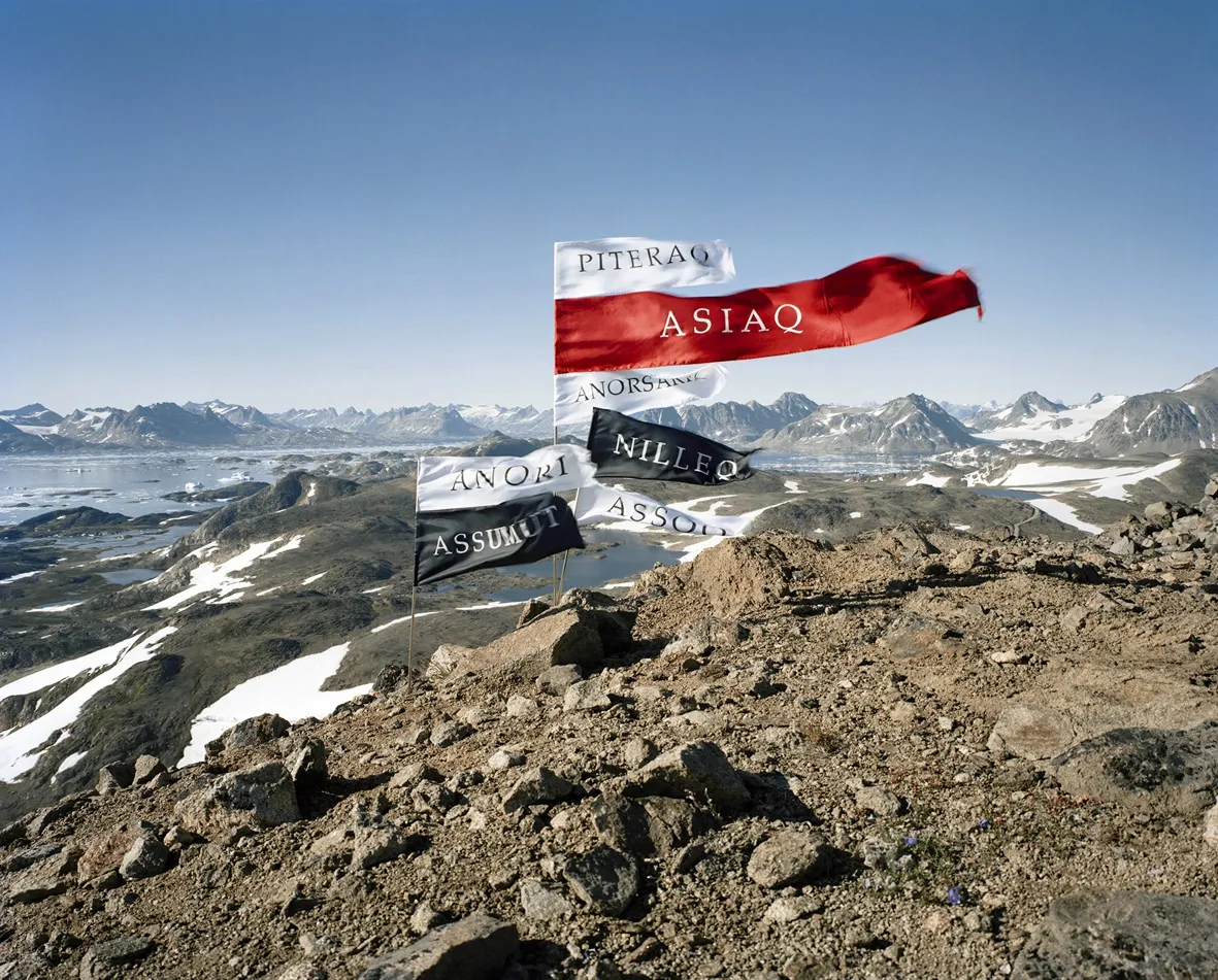 Jorma Puranen: Language is a Foreign Country 12 (Wind Words), 2001, framed pigment print, 160 x 198 cm. The texts on the silk flags are words for different kinds of winds in S&aacute;mi and Greenlandic languages. The wind moving the flags places the languages back into the landscape in a written form, missing from maps named by colonial nations.
