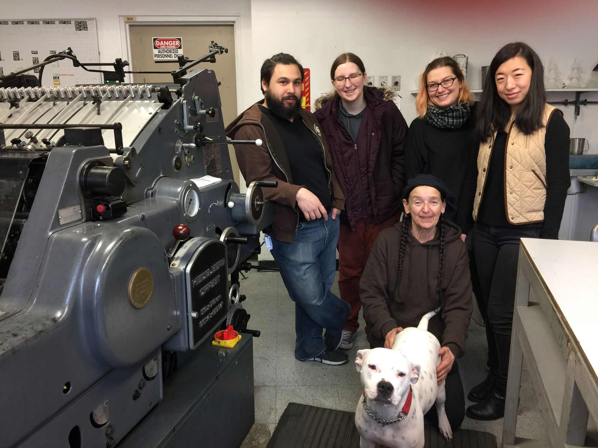 Photograph of Coe with Philadelphia printmakers and the studio pup