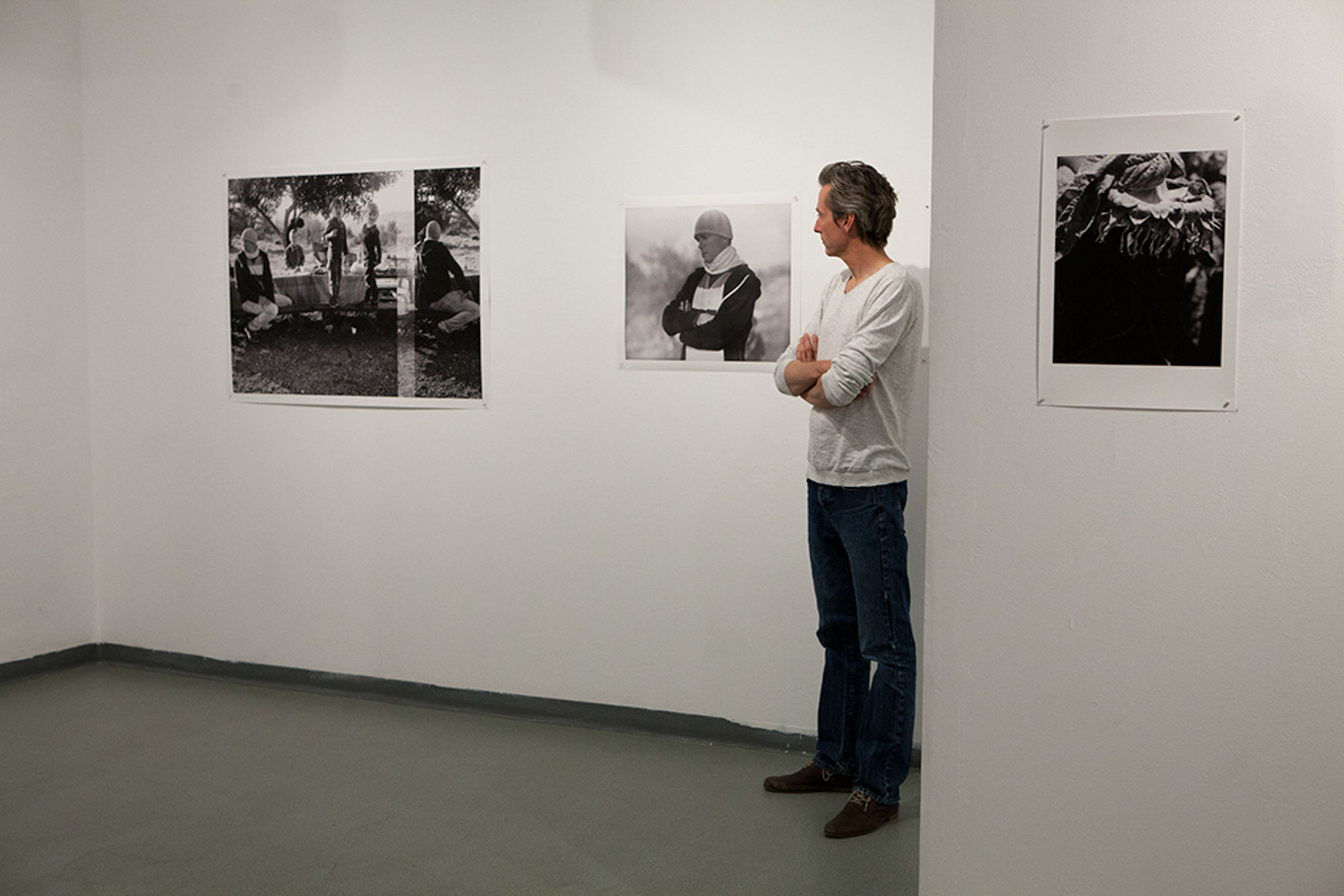 Ariel Yannay | Exhibition view: Still-life-fleeting | A viewer observing black and white photographs in a gallery, emphasizing the intimate scale of the family picnic and portrait works.