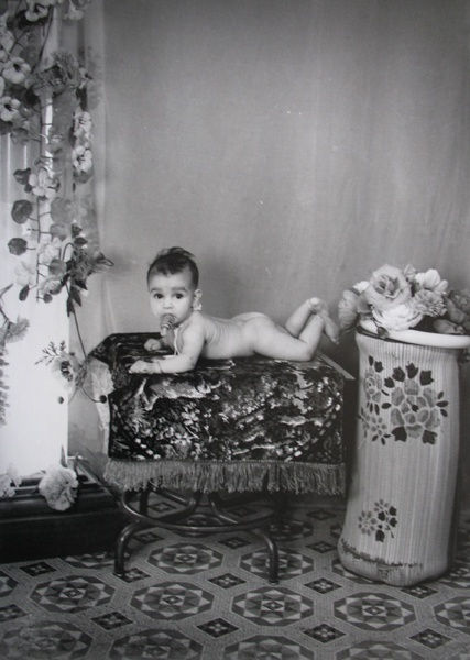 Black and white photograph of a baby in a portrait studio