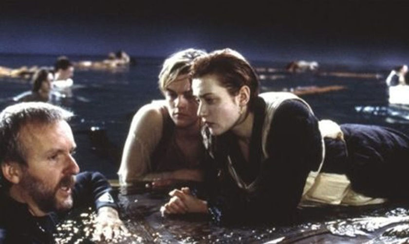 Color photograph of James Cameron, Leonardo DiCaprio, and Kate Winslet in the water on the set of Titanic