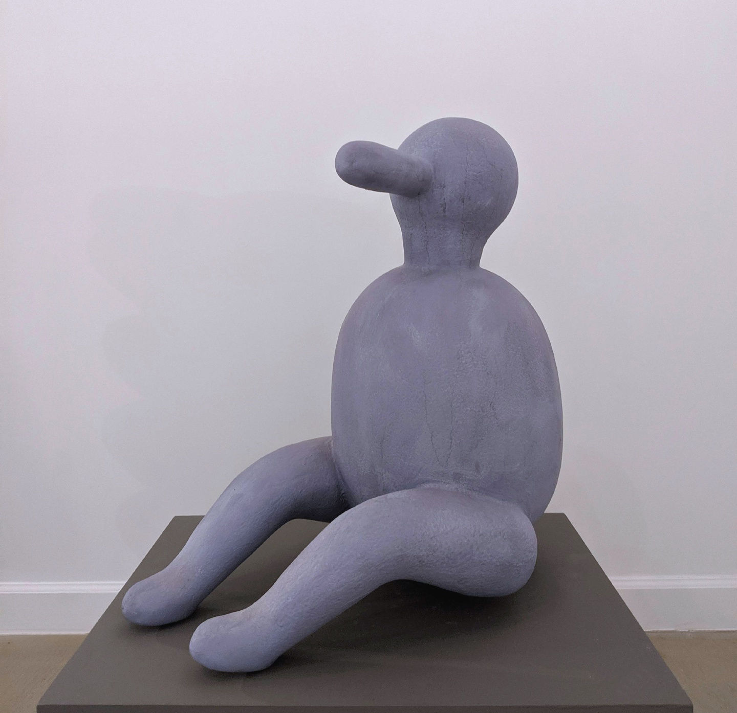 Abstracted anthropomorphic sculpture of a blue seated person