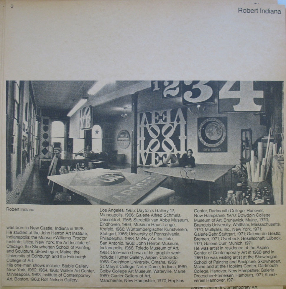 Black and white photograph of Robert Indiana in his studio with text underneath