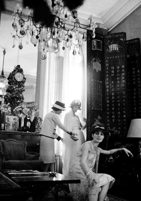 Black and white photograph of Coco Chanel with a models in her private apartment in the House of Chanel