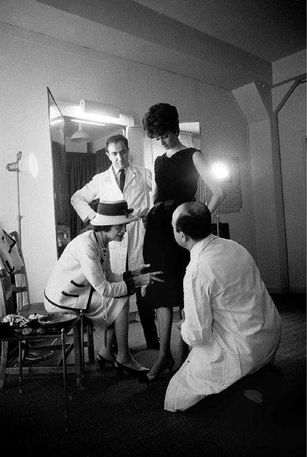 Black and white photograph of Coco Chanel with fitter Jean in the Atelier in House of Chanel