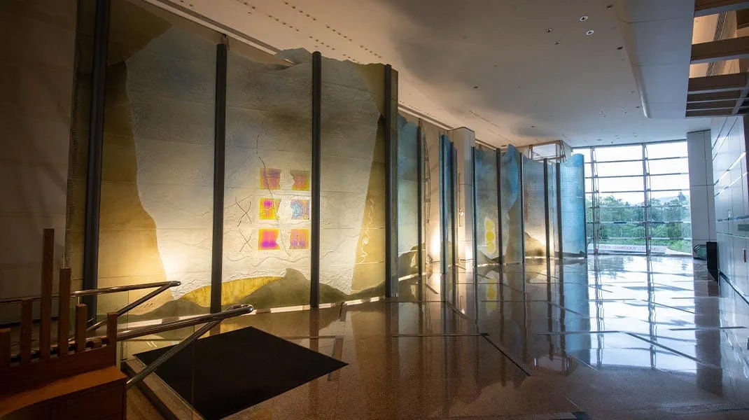 Large dichroic glass sculpture like an oversize modular screen (green, yellow, blue)