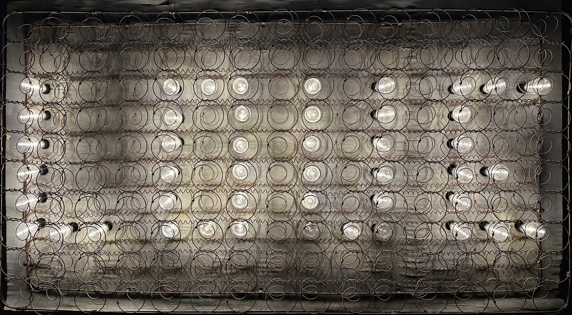 Rustic Industrial “LOVE” Wall-Mounted Light Installation – Made from a Vintage Bed Spring Frame This striking wall-mounted light installation is crafted from a vintage bed spring frame, transformed into a glowing “Love” artwork. Fitted with warm bulb lights, it blends art, design, and sustainability, making it a truly one-of-a-kind statement piece.
