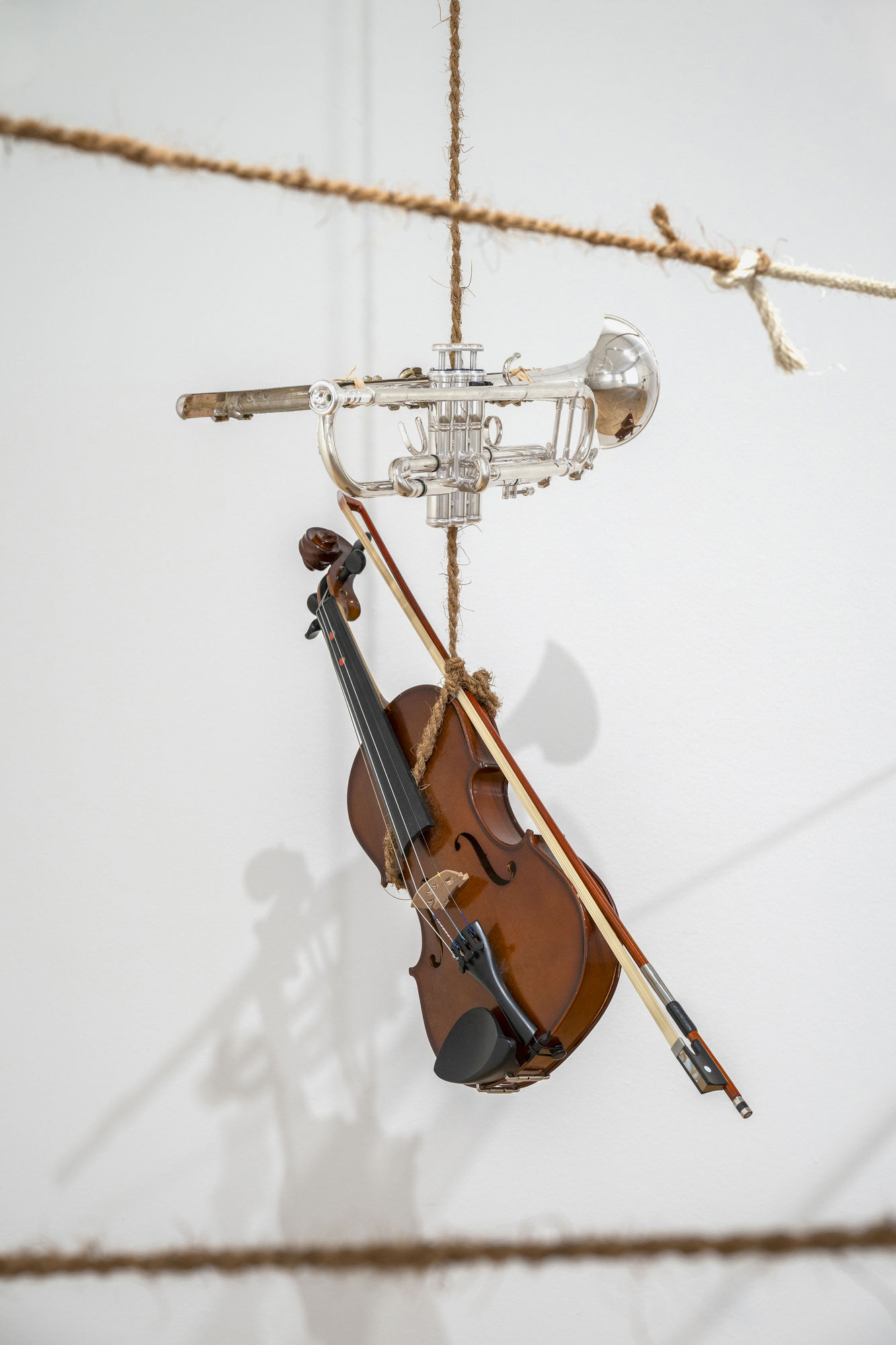 Pulleys (Put In, Take Out/The Unanswered Question) 2024 Installation (Sculptural Situation) Various pulleys, ropes of different kind, Sicilian basket with texts with signs written in Italian and English, a violin, and two half-cut musical instruments (a trumpet and a flute grafted together) Dimensions vary with installation Comes with an installation manual and signed certificate Unique