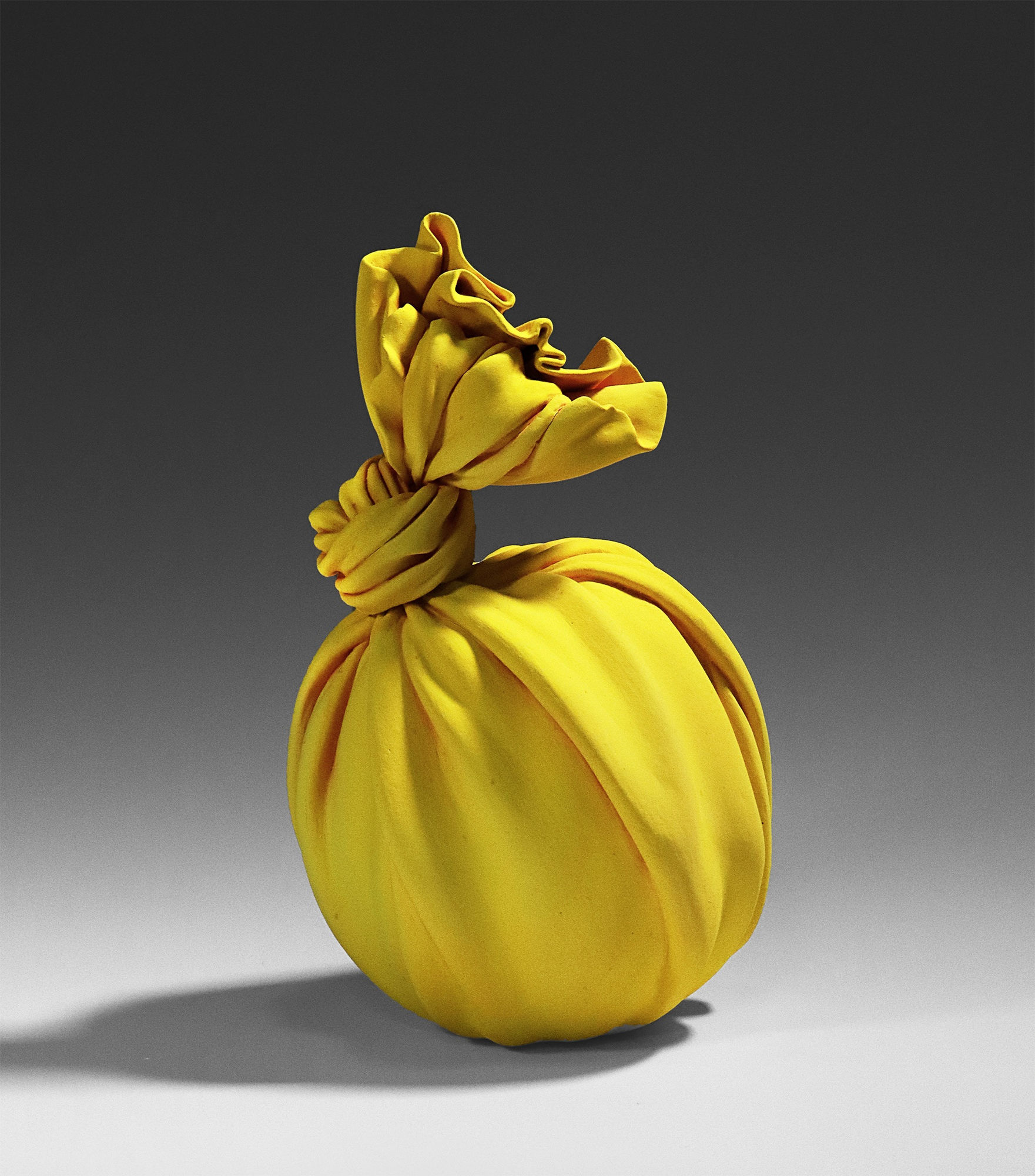 Tanaka Yū (b. 1989) Yellow sculpture in the shape of knotted furoshiki (wrapping cloth) enclosing a round vessel 2019 Matte-glazed stoneware 7 1/8 x 7 1/8 x 10 5/8 in. Inv# 11241 SOLD