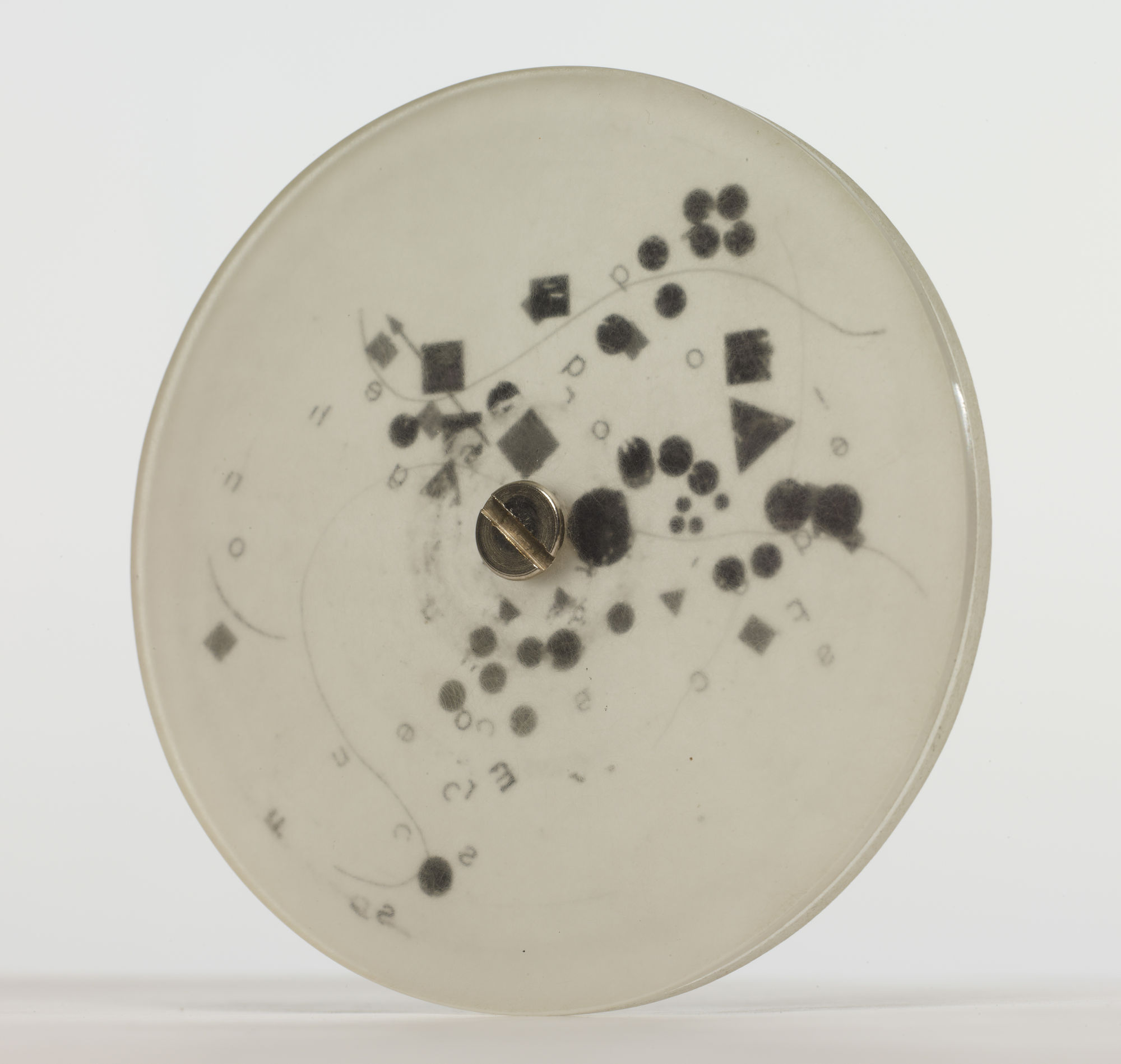 Mira Schendel Sem título [Untitled], da série [from the series] Discos [Discs], 1971 - 1973 acrílico opaco, letraset e parafusos [acrylic glass (opaque), transfer lettering (letraset), sccrew] ø 9 x 0.6 cm [ø 3 1/2 x 1/4 in]