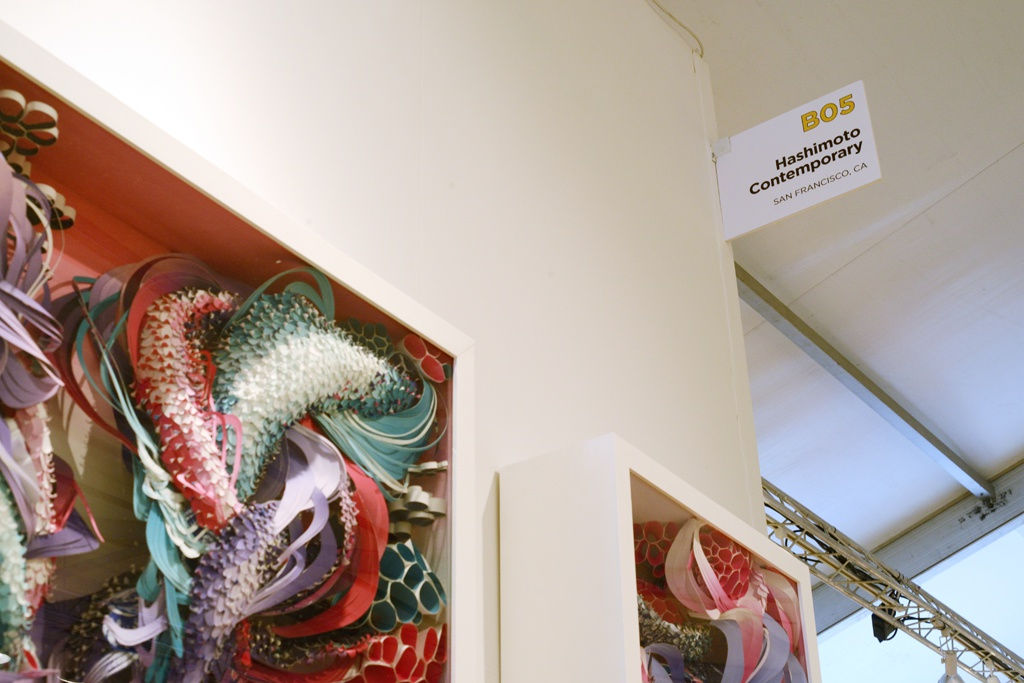 Art fair booth installation sign with Crystal Wagner multicolored multimedia work in foreground 