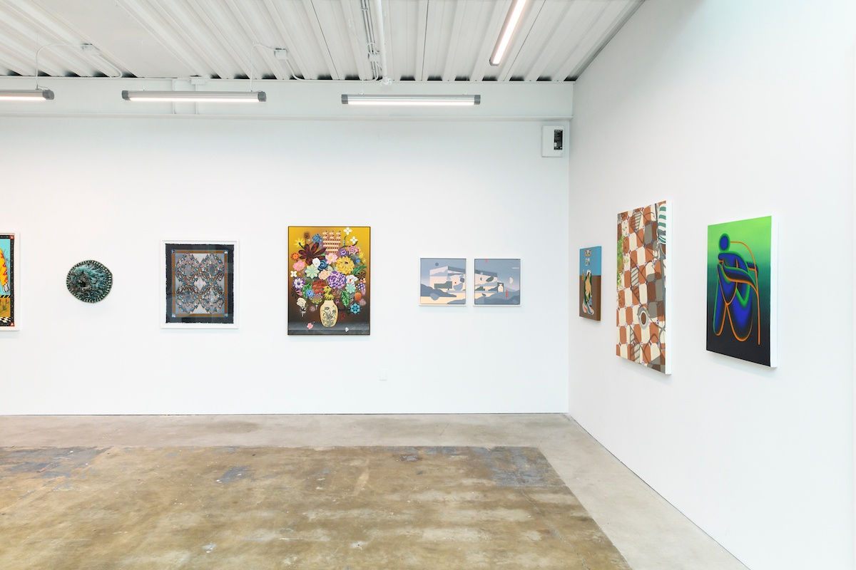 Photo of paintings hanging on white walls in a gallery 