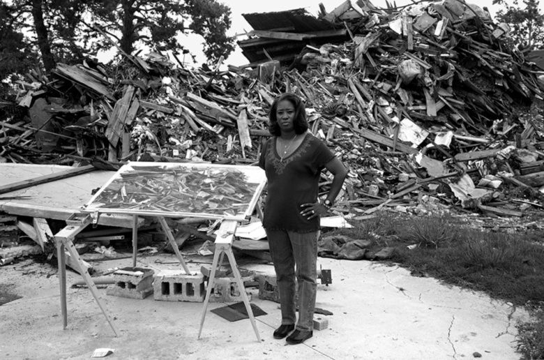 Lewis Watts By the remains of the house built by her father, Lower Ninth Ward, 2006 archival pigment print 35 x 44 in.