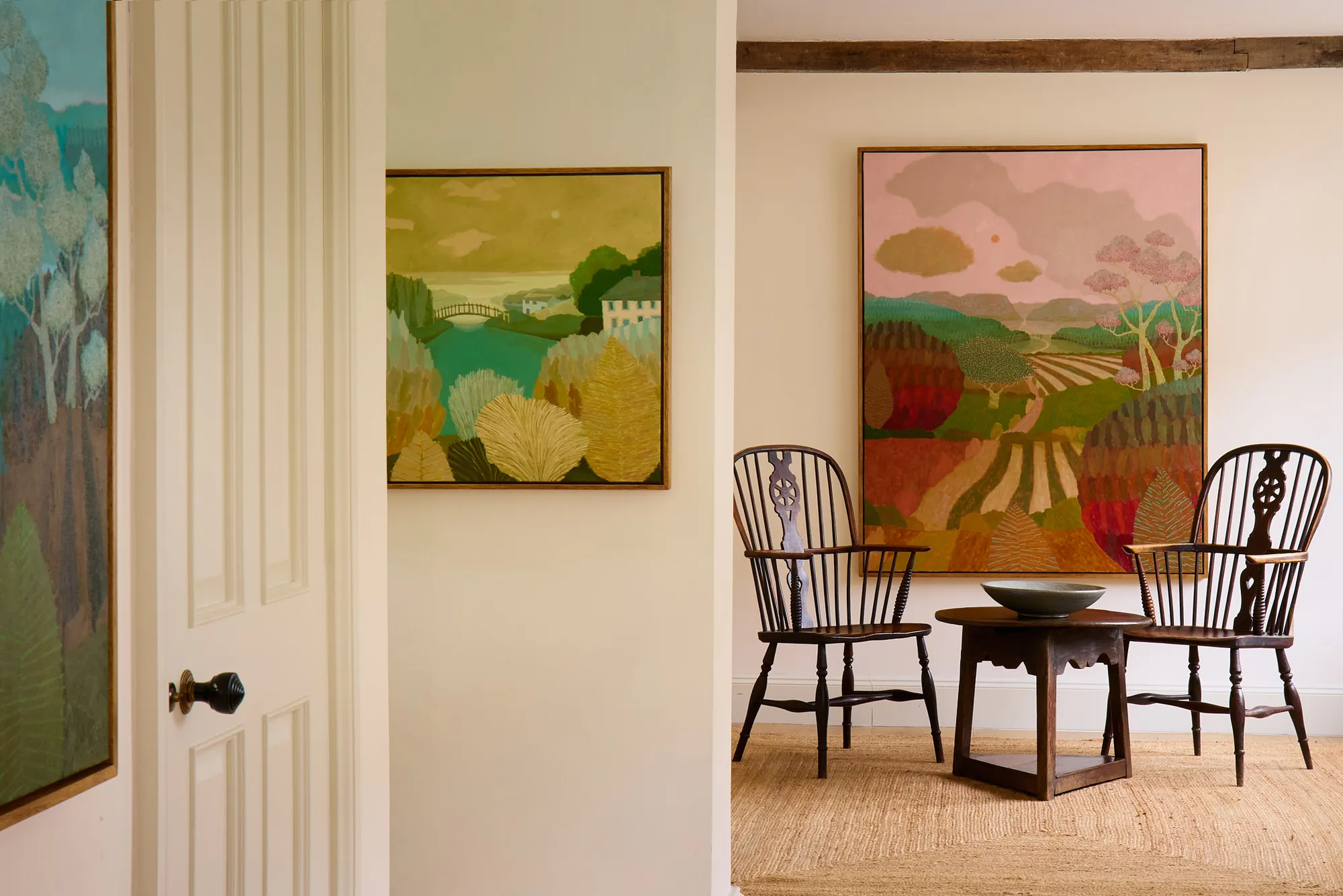 Bright cottage dining area featuring landscape by Richard Ballinger and Aldermaston pottery set above bookshelves