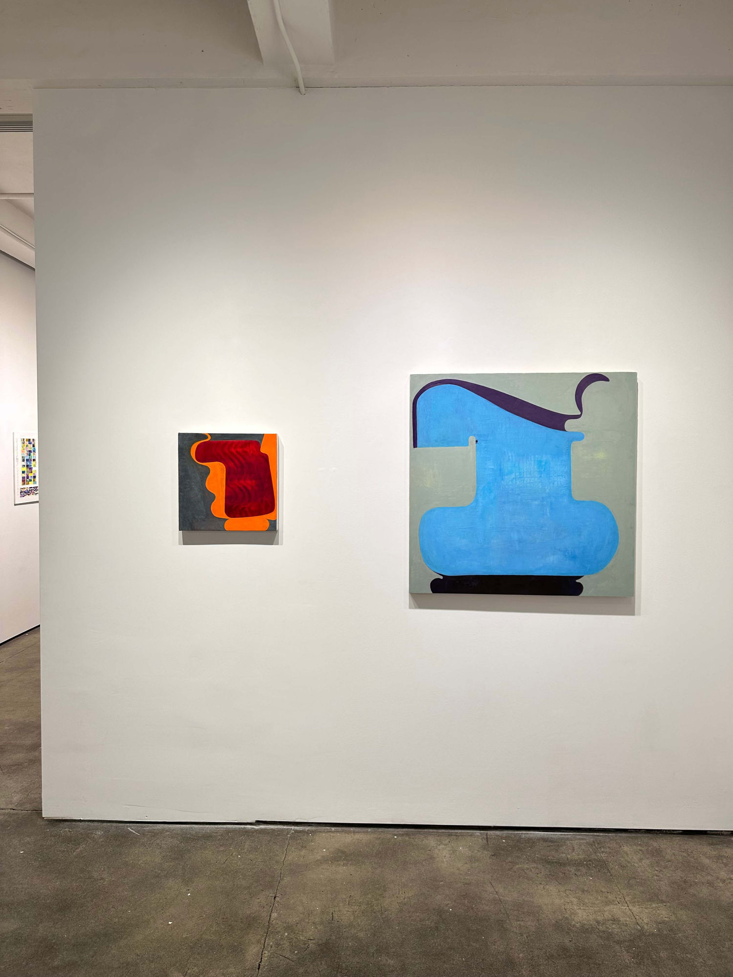 exhibition with two abstract paintings on the wall