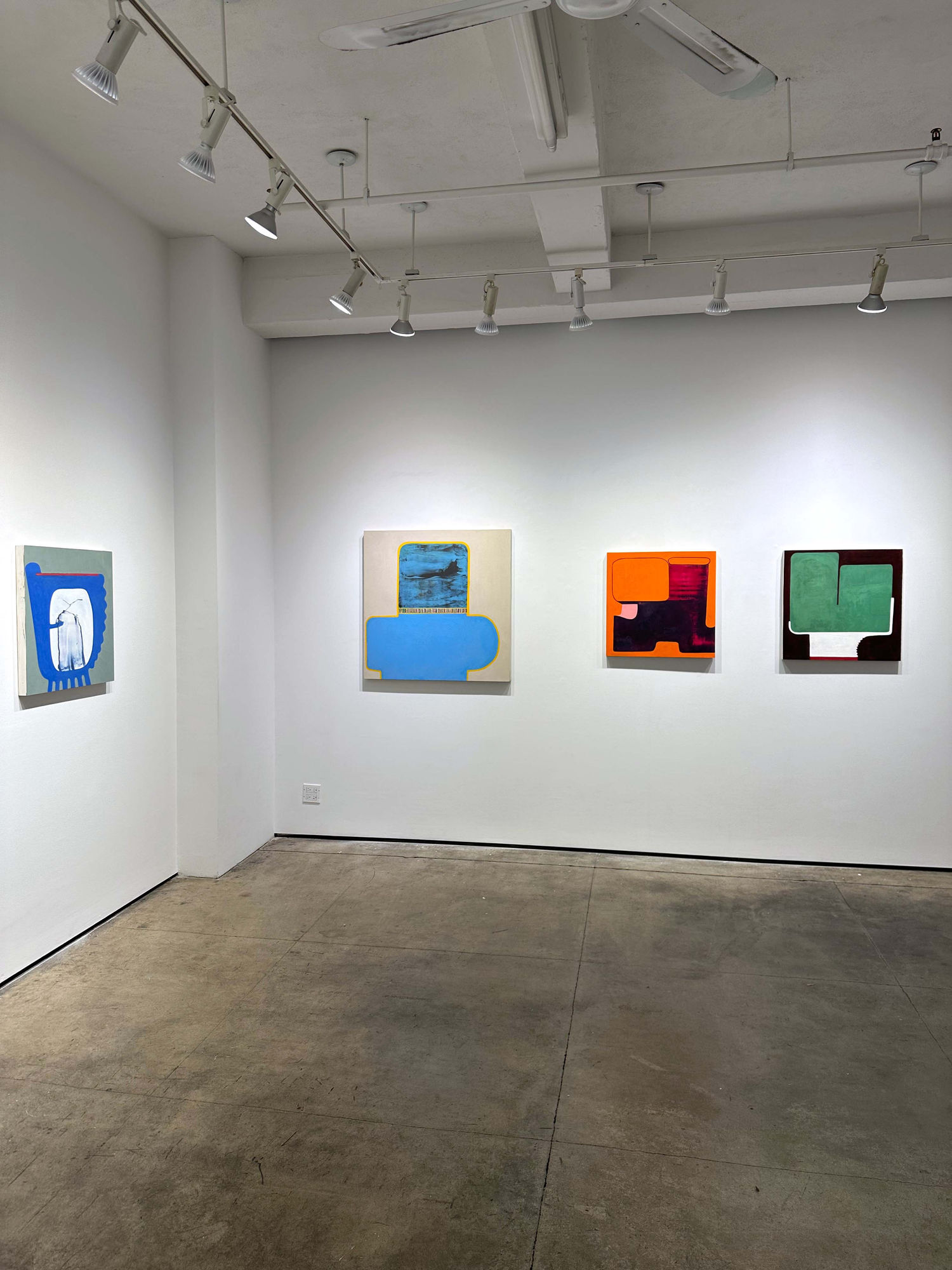 exhibition with four paintings visible on the walls