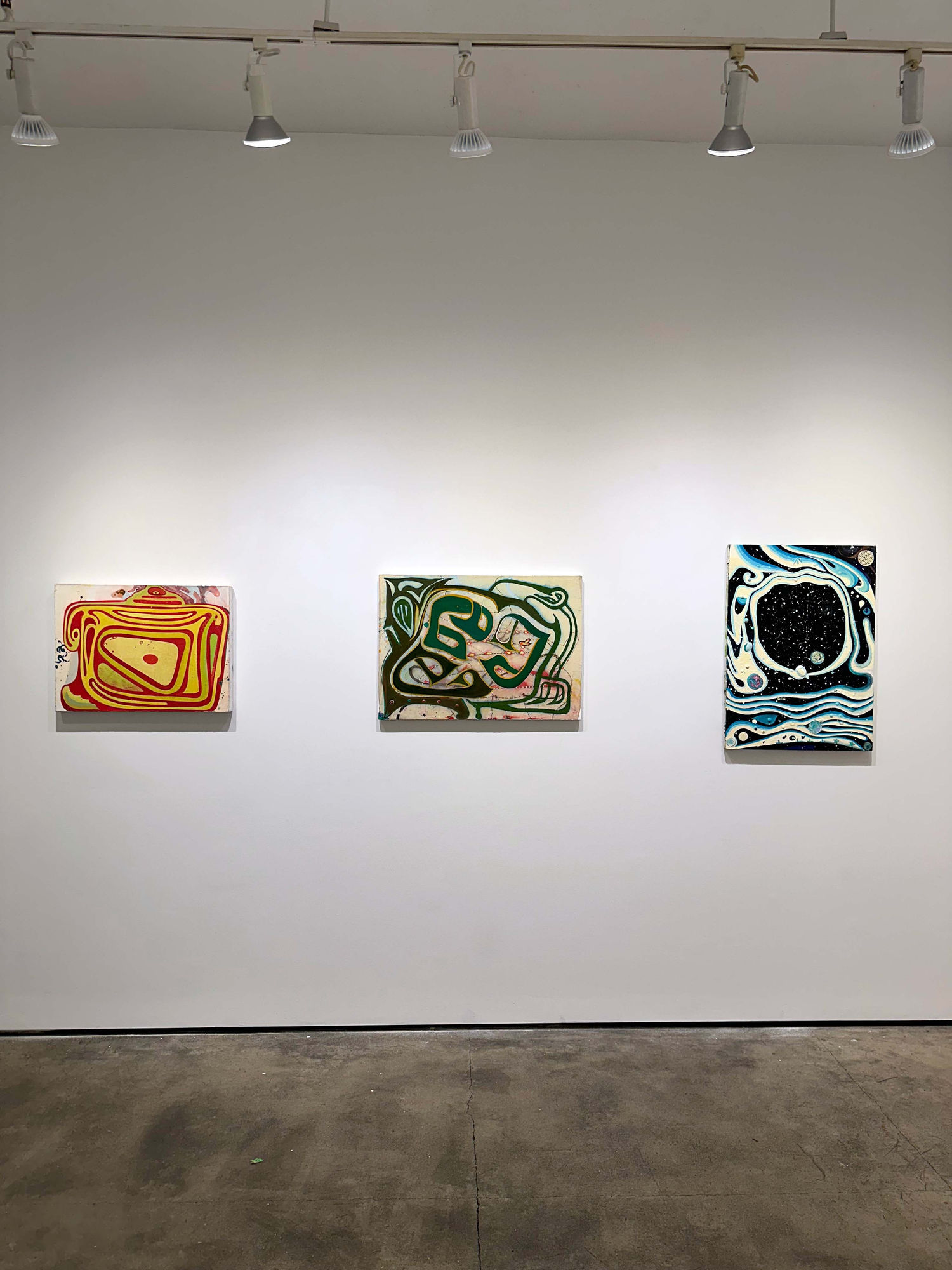 exhibition with three paintings on a wall