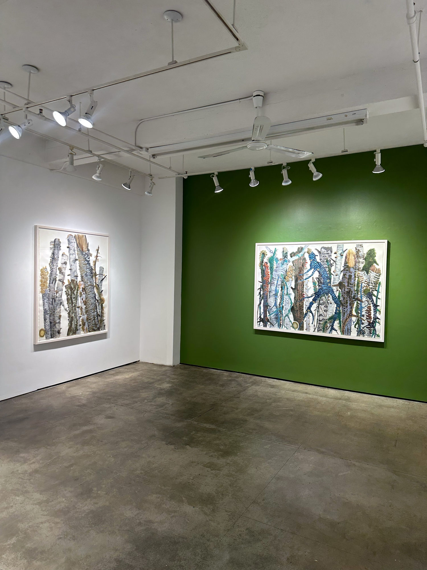 exhibition with two paintings on the walls, one of which is green