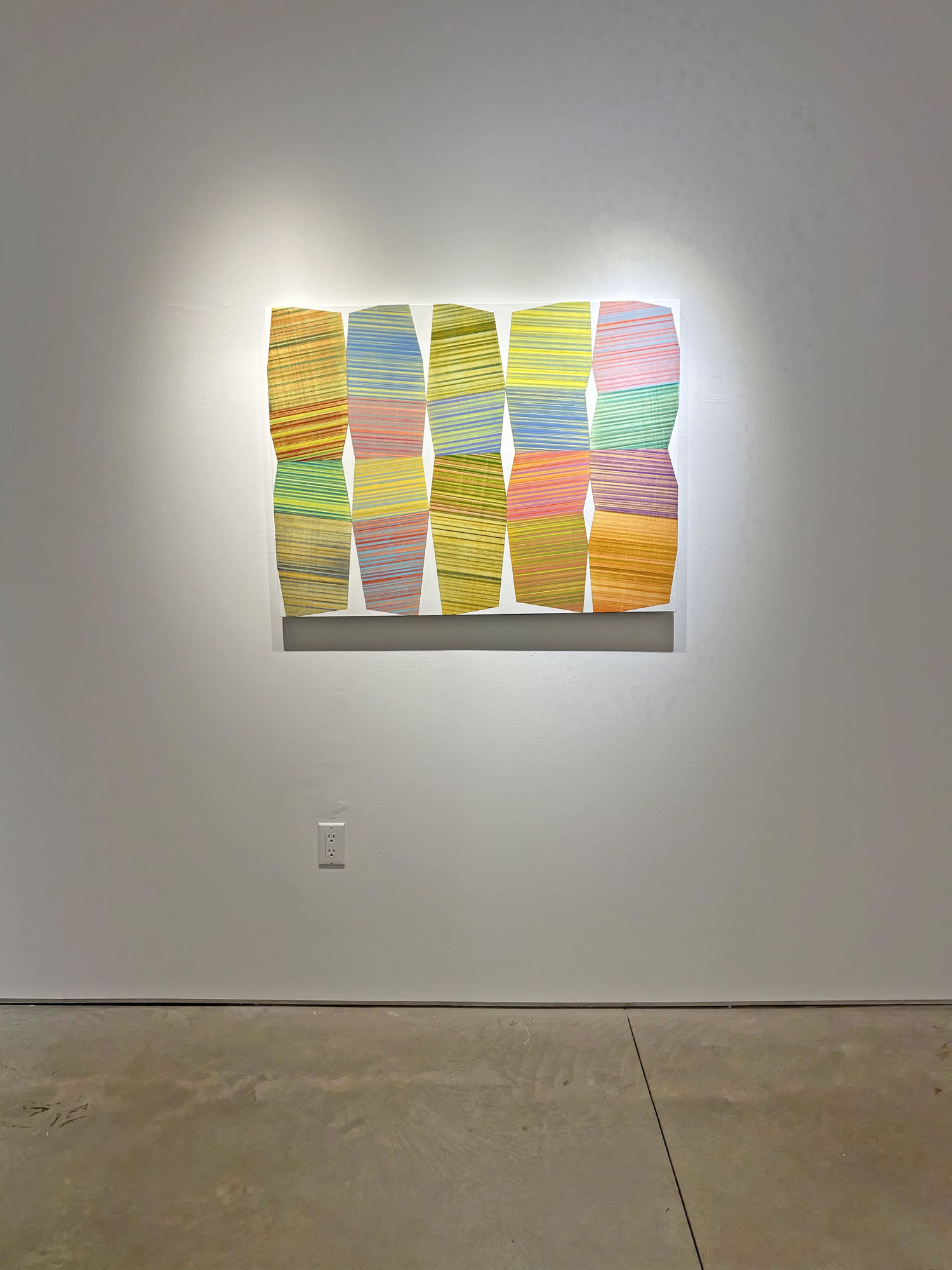exhibition with one abstract painting lit up on the wall