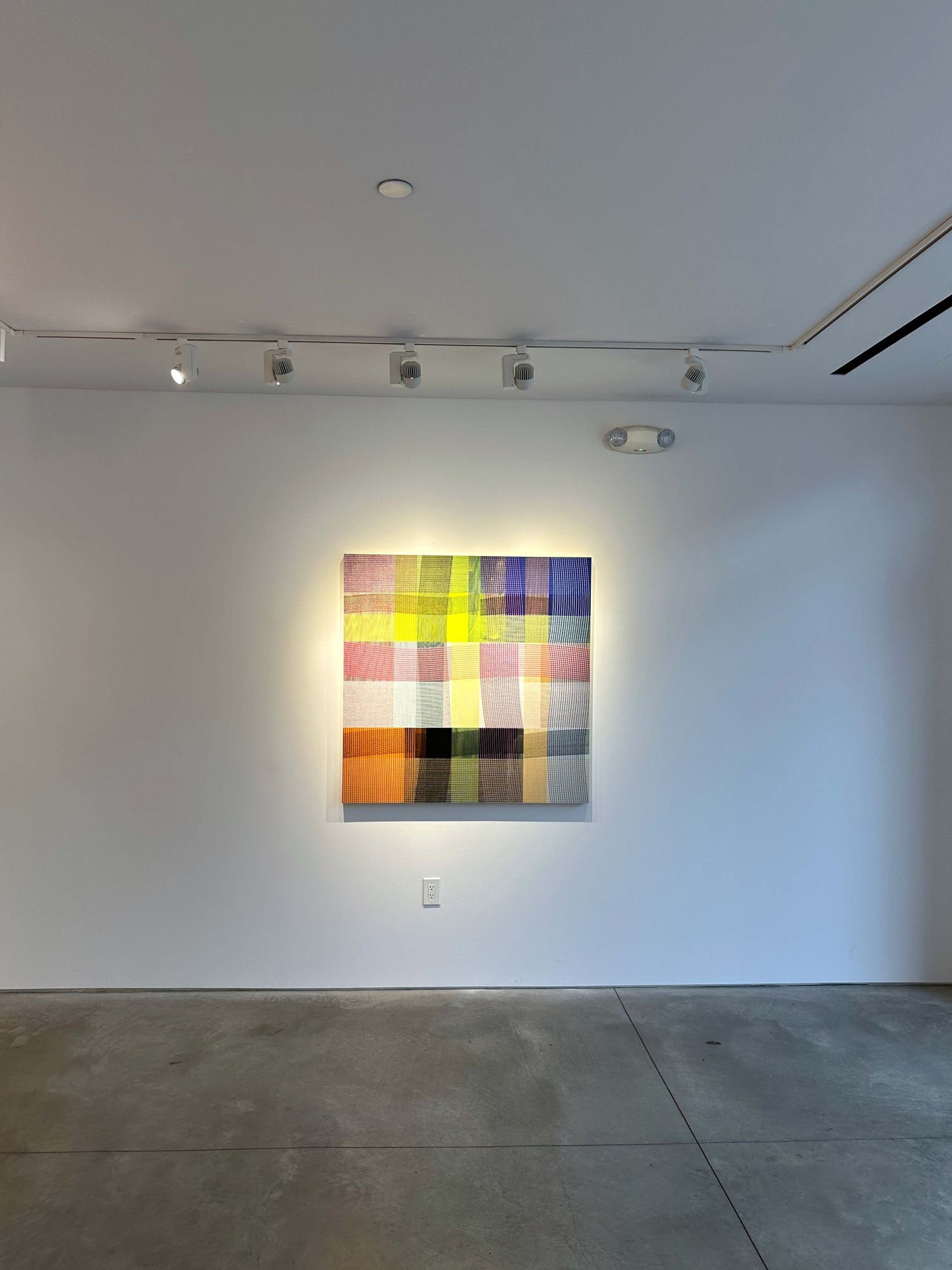 photo of an installation with one abstract painting visible.