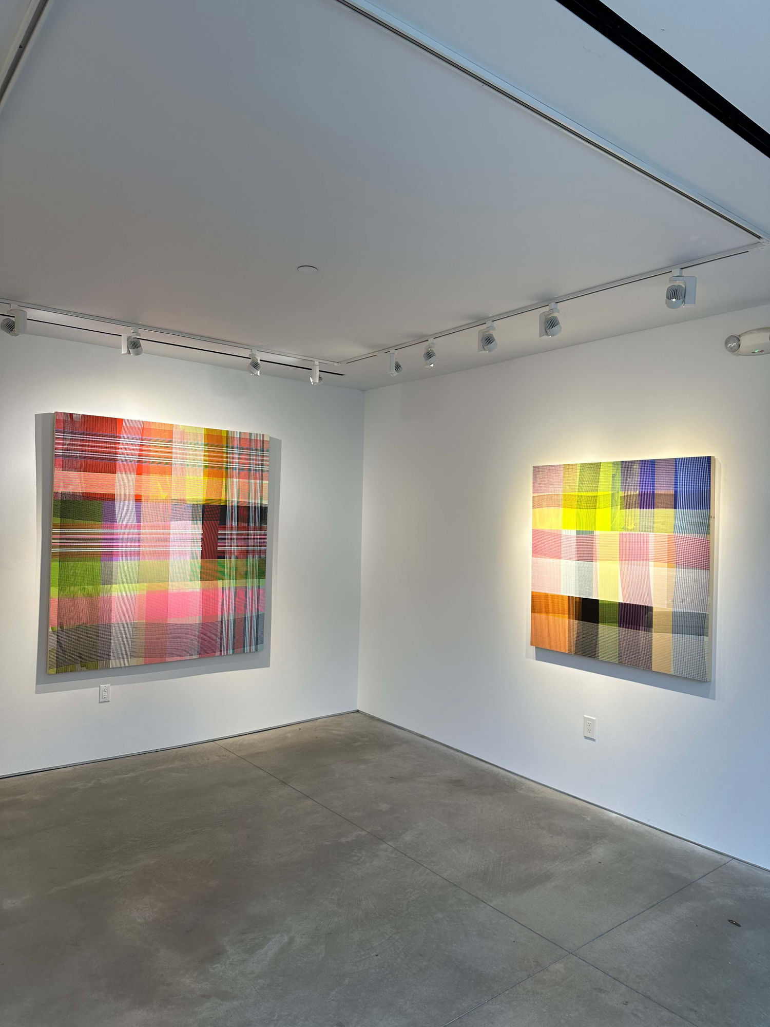 photo of an installation with two abstract paintings visible.