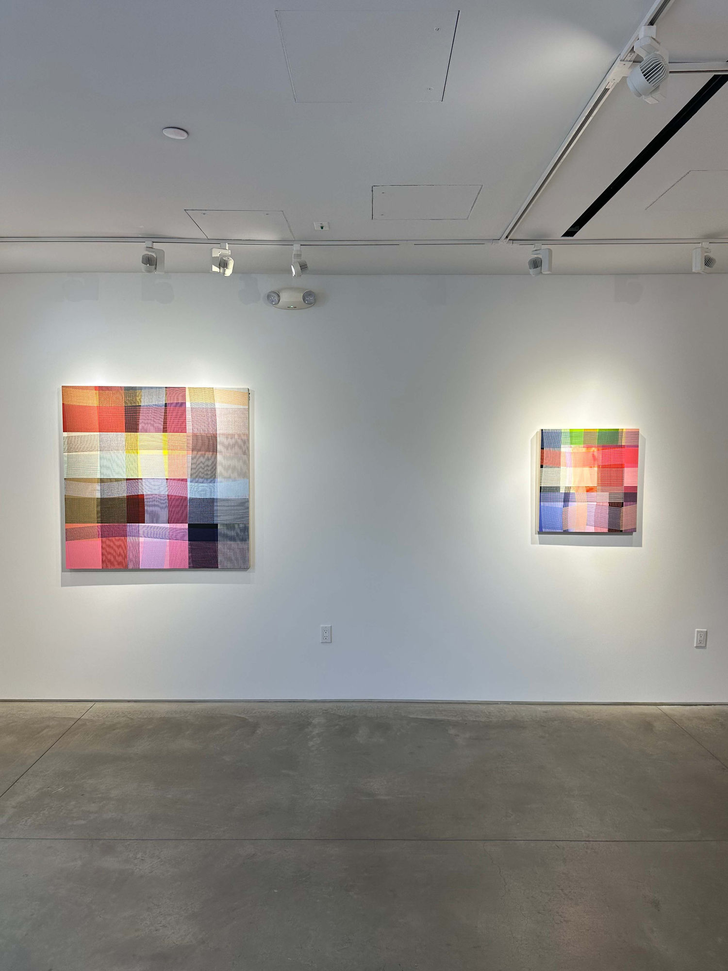 photo of an installation with two abstract paintings visible.