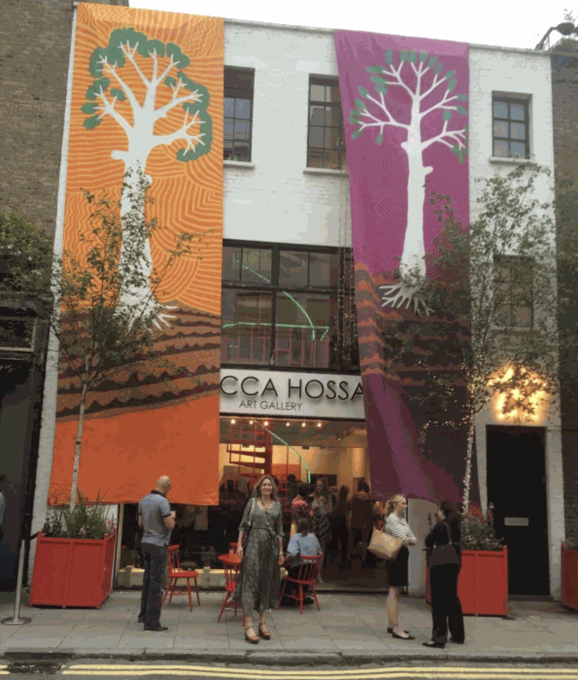 Rebecca Hossack outside the gallery with Jimmy Pike's banners