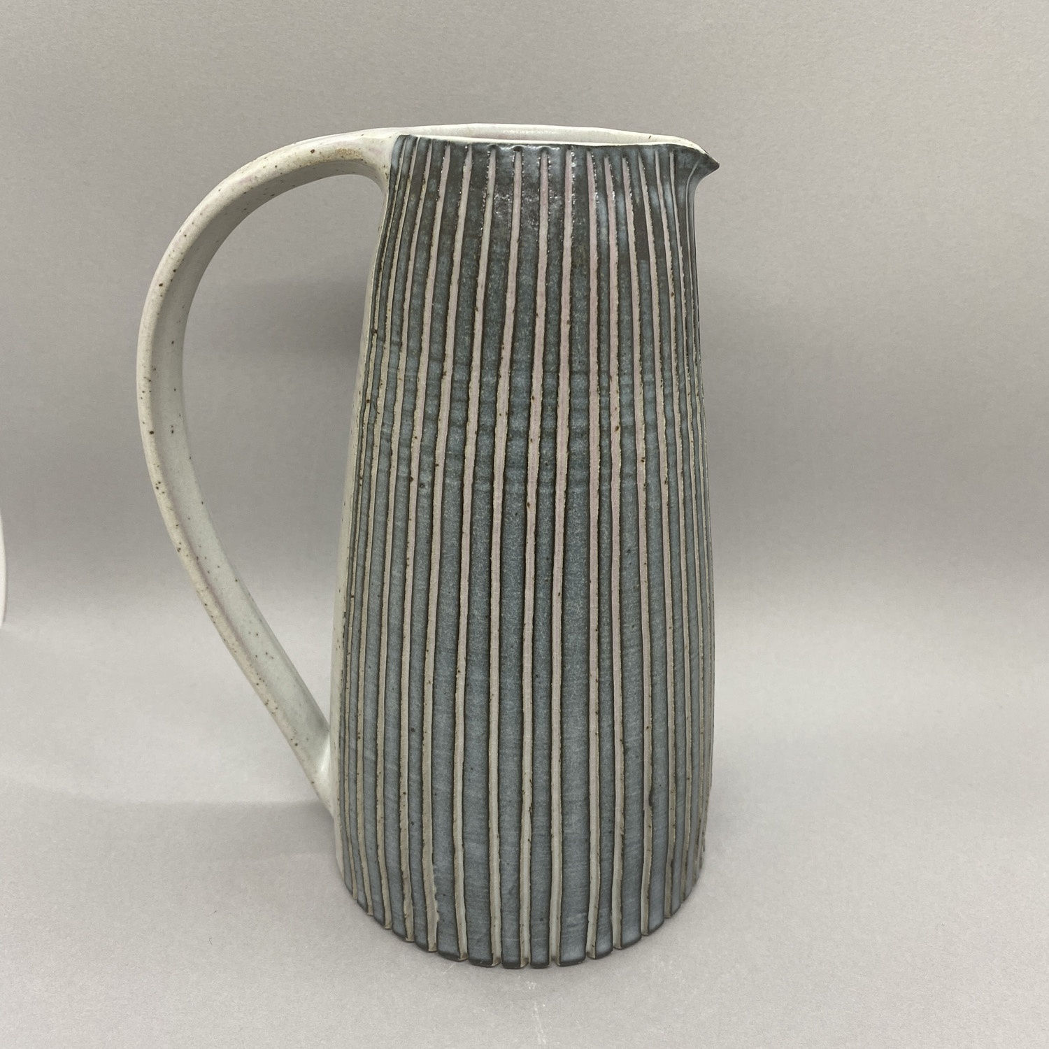 Kate Garwood tall jug in a straight shape with narrow dark blue stripes.