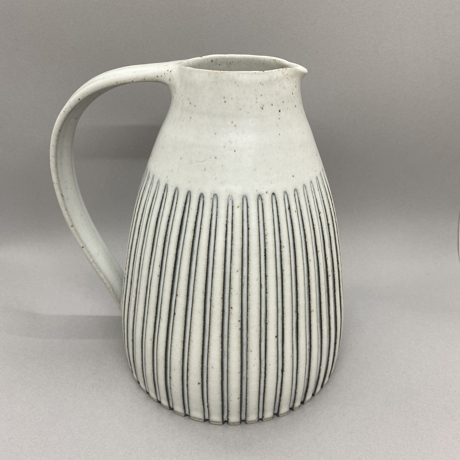Kate Garwood white tall jug with slightly round shape, with thin blue stripes.