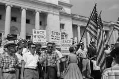 A group of people, several holding signs and American flags, protesting the admission of the "Little Rock Nine" to Central High School, Little Rock, Arkansas, 1959 (Courtesy Library of Congress).