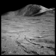 Rover Tracks and Mount Hadley Rising 15,000 Feet Over the Marsh of Decay;, Photographed by James Irwin, Apollo 15, July 26-August 7, 1971