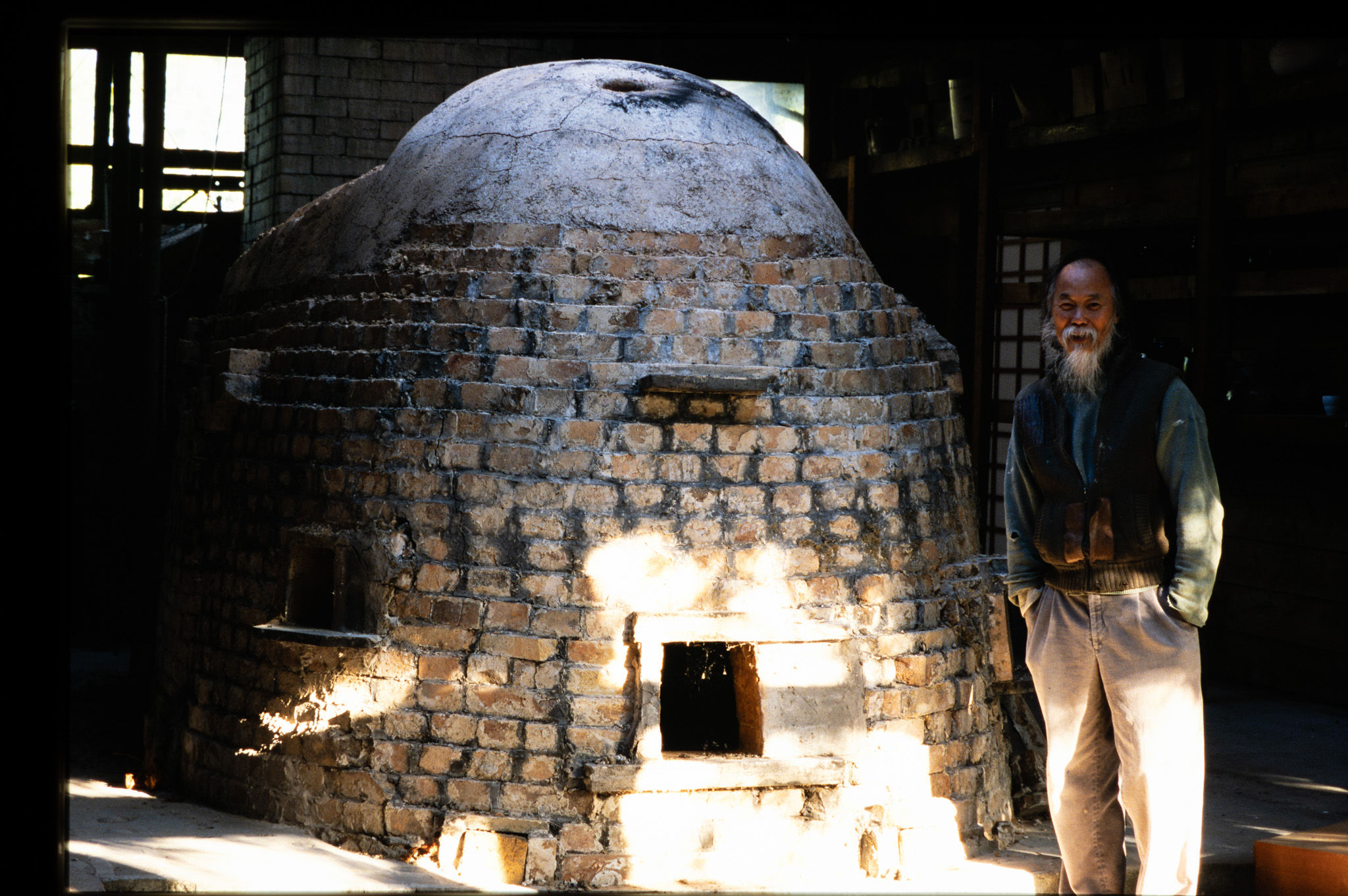 Wayne Ngan in front of his kiln, Ostby Road studio, Hornby Island, BC.