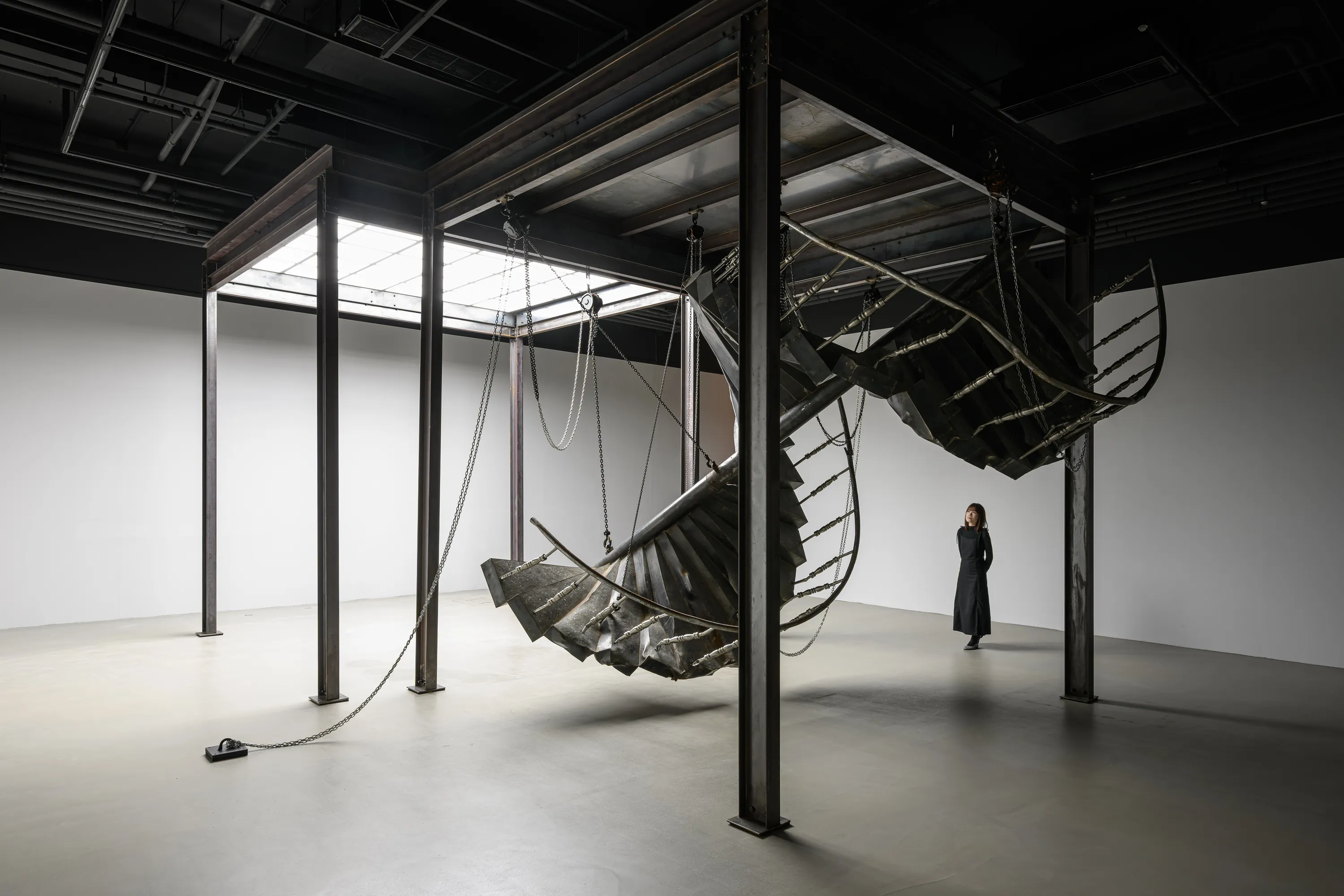 雕塑之於當代藝術形式演化而言，其形式早已逸出古典傳統所標舉的紀念性與再現性框架，不再僅作為宗教敘事或英雄史觀的象徵載體，而是在二十世紀以降，伴隨藝術對形式與價值體系的反思深化，雕塑逐步由超越性的崇高象徵，轉向對日常政治與現實處境的回應，開始觸及勞動、性別、族群與記憶等具體而微的生命經驗。伴隨此一價值轉向，媒材亦隨之開展。工業材料、現成物，乃至聲音與行動的引入，使雕塑不再依附於貴重材質所建構的權威與永恆性，而轉向一種開放且關係性的實踐形態。在邱承宏的創作中，其迴避了以事件指涉內容作為塑形的考量，而期望以作品作為回應時間、空間、身體的媒介，進而顯示抽象意念之視野，也促使了當代雕塑得以指涉遠超於自身形式所能承載的意涵。對邱承宏而言，所謂的秩序，或說雕塑語言詮釋後的樣態，是一種經由修補後的圓滿，透過將缺口與殘片重新修復，亦或是使缺口自身透過藝術的形式獲得美學上的新生，舉凡動植物及有機物件的外在生命樣態及其缺陷或傷口，藝術家希望可以將這些體察轉化為另一種完整造型的基礎，正如日本工藝「金繼」將陶罐的傷口成為造型的一部分，其作品中對於碎片與缺失的關懷貫穿了藝術家生涯最核心的價值觀。 以其作品〈水泥動物園〉為例，邱承宏曾言：「我覺得水泥動物的出現，就像是某個時代的填充物，我自己是把他們想像成一種缺乏自信的雕塑。」這些由不知名工匠製作、造型滑稽笨拙的水泥動物雕像，既缺乏專業雕塑家製作時對於黃金比例的考究，其在材料上亦非大理石、銅及不鏽鋼本身所期許的完美與永恆。然而正是這些不穩定、崩壞、充滿缺陷的雕塑，在美崙山裡以旺盛的生命力回應了雕塑中最重要的使命，記錄下時間的重量與意義。 在本次展覽中，邱承宏以地震倒塌建築中回收的鋼筋、磚瓦與混凝土為基礎材料，重構出旋轉樓梯、櫃體結構、與仿生燈具等雕塑形體，彷彿在一片崩壞的現實中尋索出一種異質卻相互依存的秩序。作品〈失衡的螺旋〉中的螺旋造型取法自然界的費波那契數列與 DNA 雙螺旋結構&mdash;&mdash;那象徵生命生成與自我複製的基本法則。然而在此，螺旋不再穩定向上、循環不息，而是帶著偏斜與裂縫的軌跡，顯露出斷裂、錯置與再生的痕跡。每一階梯面如同模具般承載來自不同災難場域的殘片，表面則以磨石子質地封存時間與磨損的層層疊積，像是將地質層理的運動視為一種雕塑生產的過程，凝結為一種看似建構、實則失衡的螺旋結構。