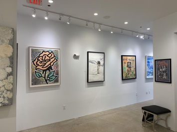 Interior photo of gallery with framed artwork on the wall.