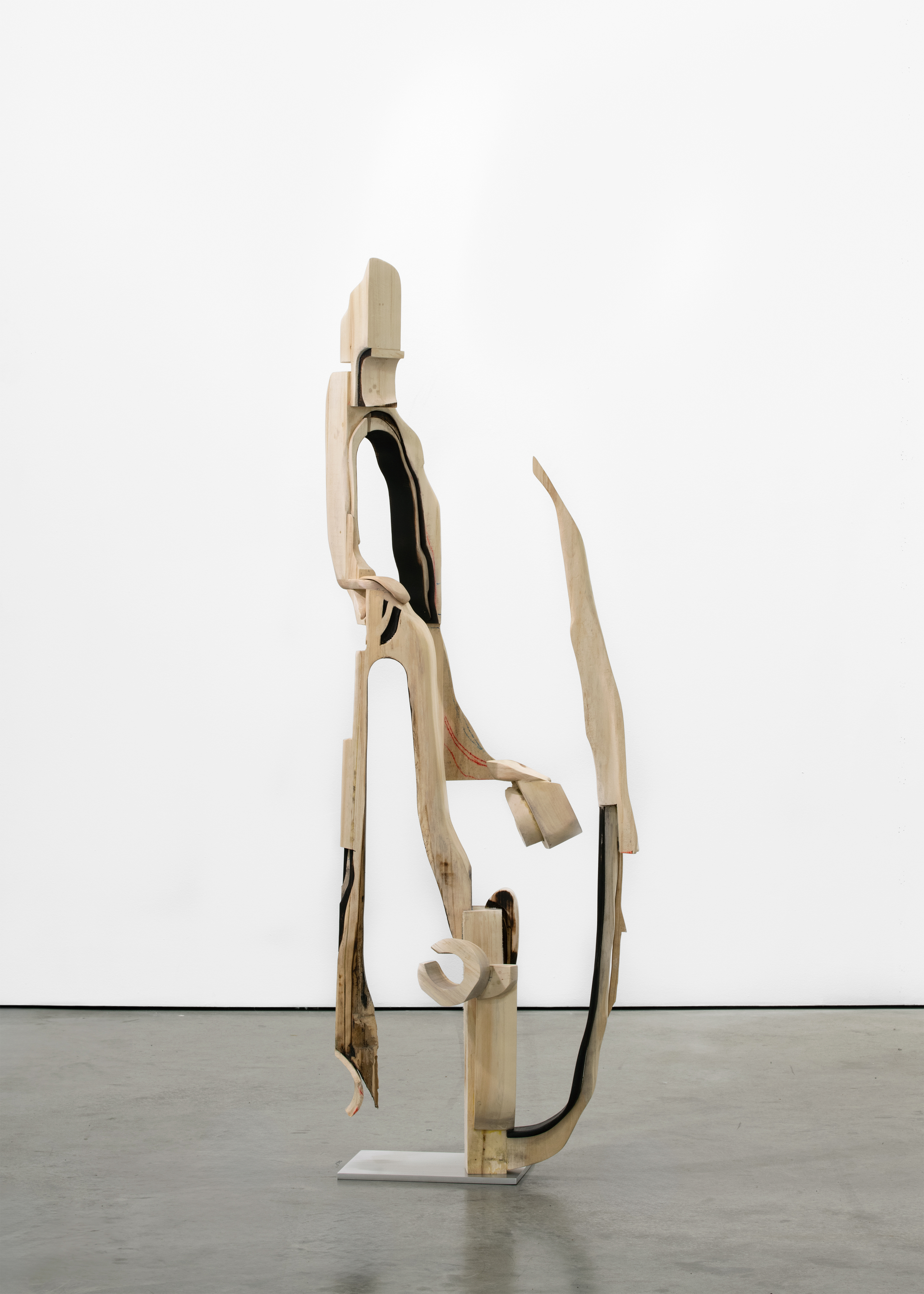 A freestanding sculpture by David Armstrong Six made of wood carved into an abstracted geometric form.