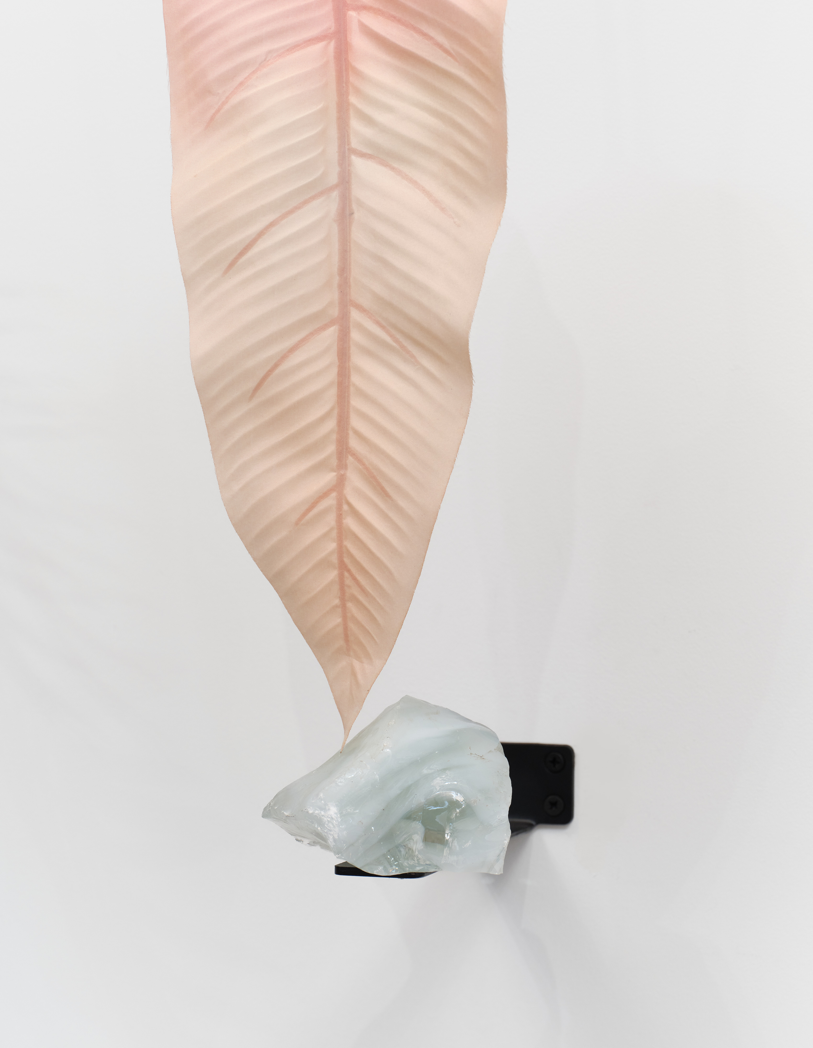 A detail of a plastic pink leaf touching a glass stone in Rachel Youn's "Herald"